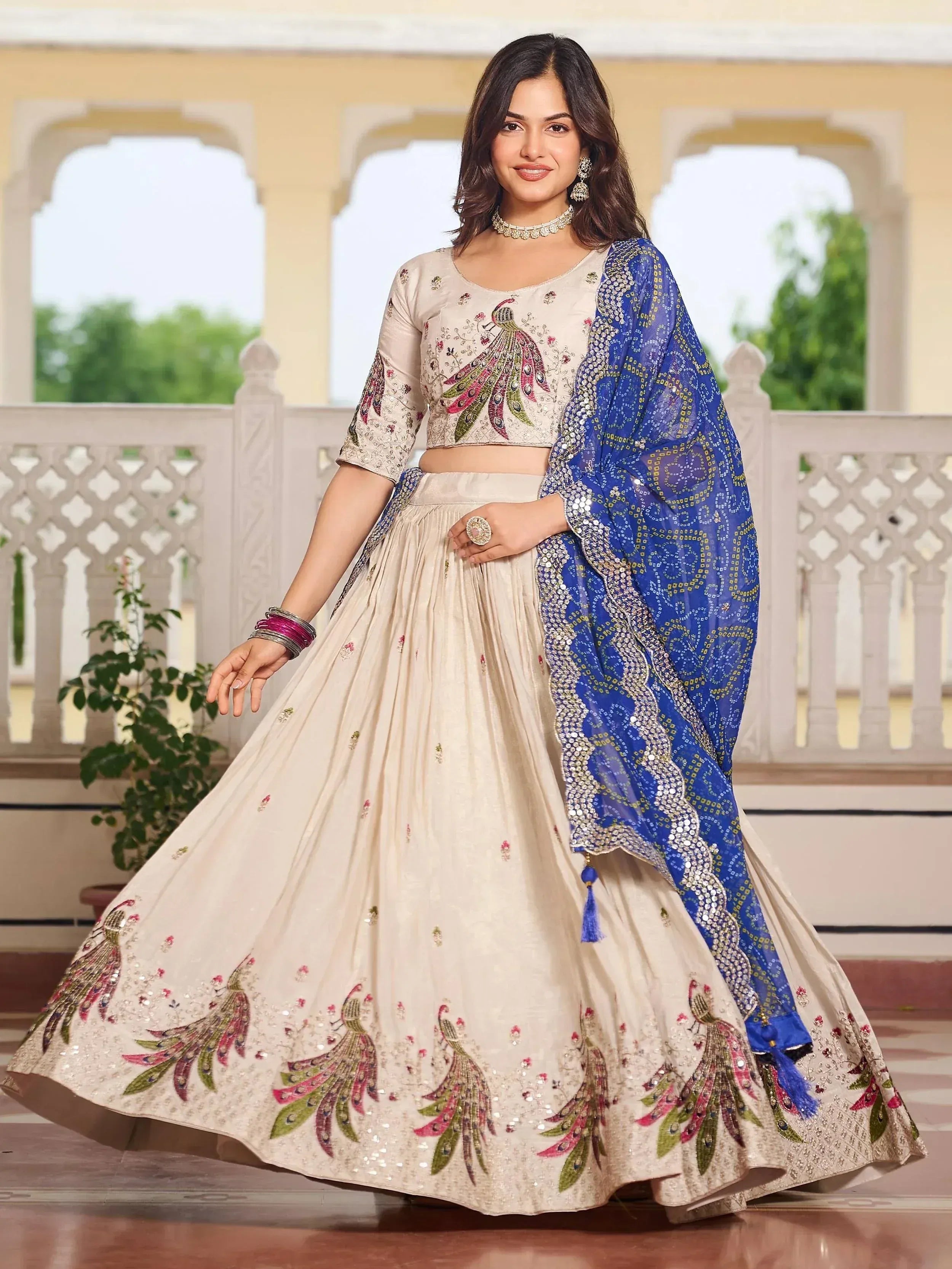 Cream peacock-embroidered lehenga choli with blue dupatta, Indian ethnic wear for weddings and festivals