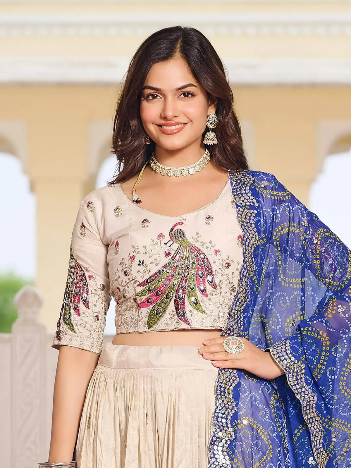 Woman in beige embroidered lehenga choli with peacock design and blue dupatta, Indian ethnic wear