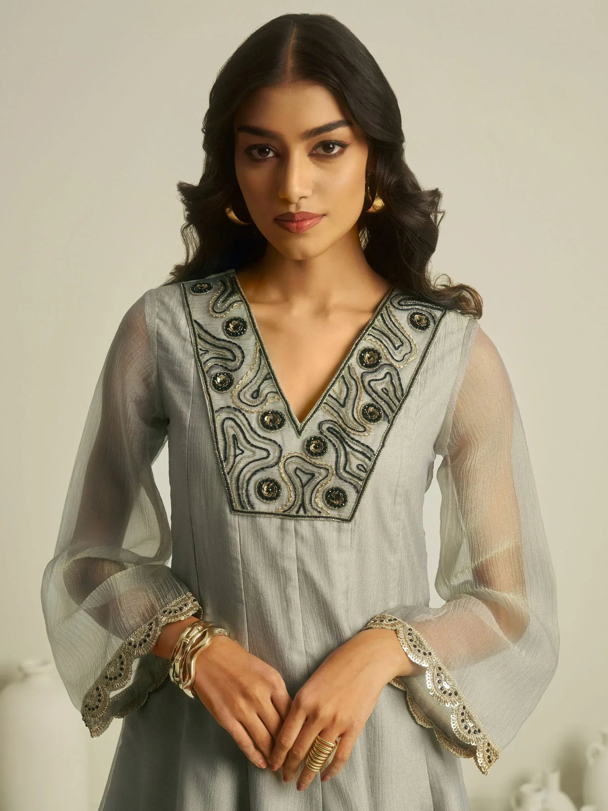 Grey ethnic kurti with intricate black and gold embroidery, sheer sleeves, and V-neck design