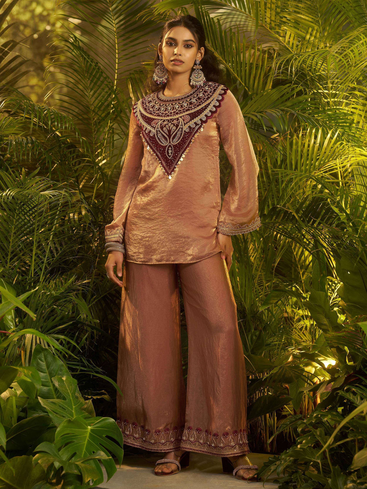 Elegant maroon and gold embroidered ethnic kurta with palazzo pants, styled with statement earrings.