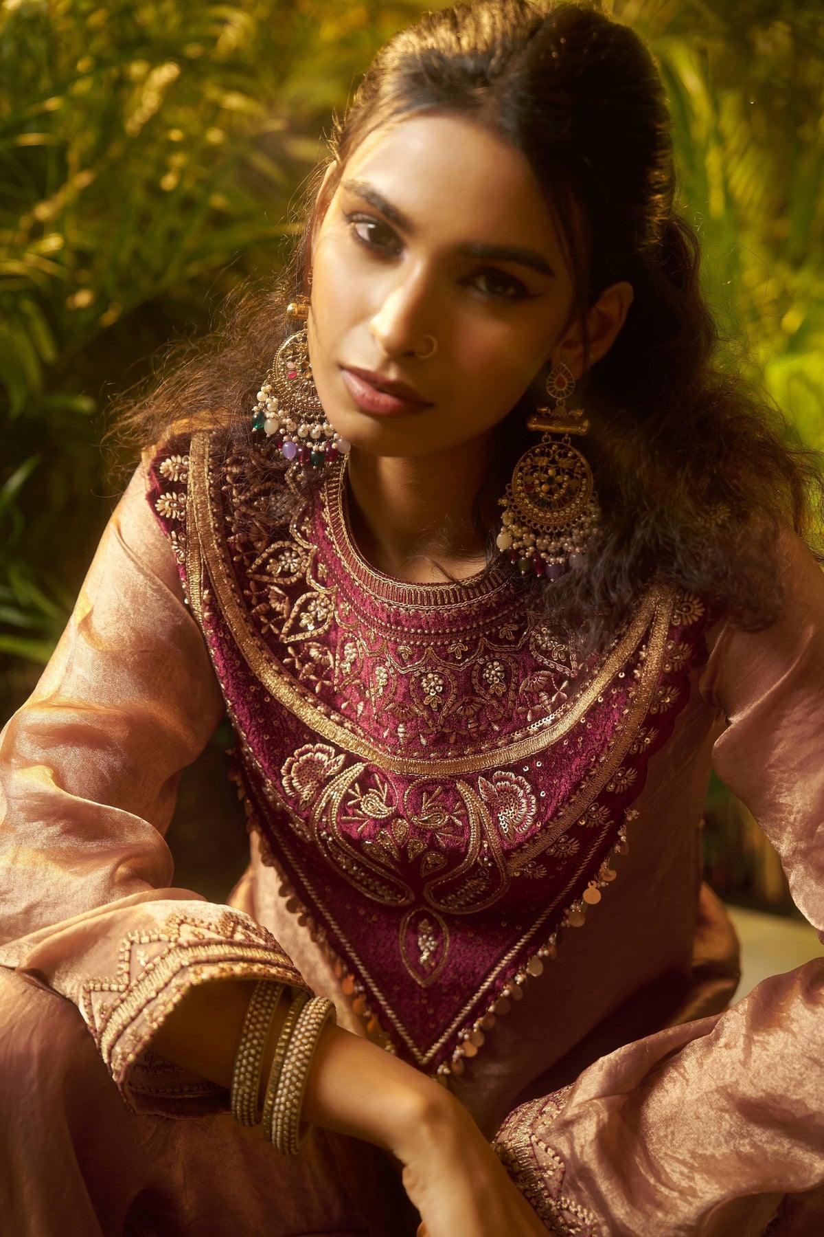 Elegant maroon and gold embroidered ethnic blouse with statement jewelry, perfect for Indian festive occasions.