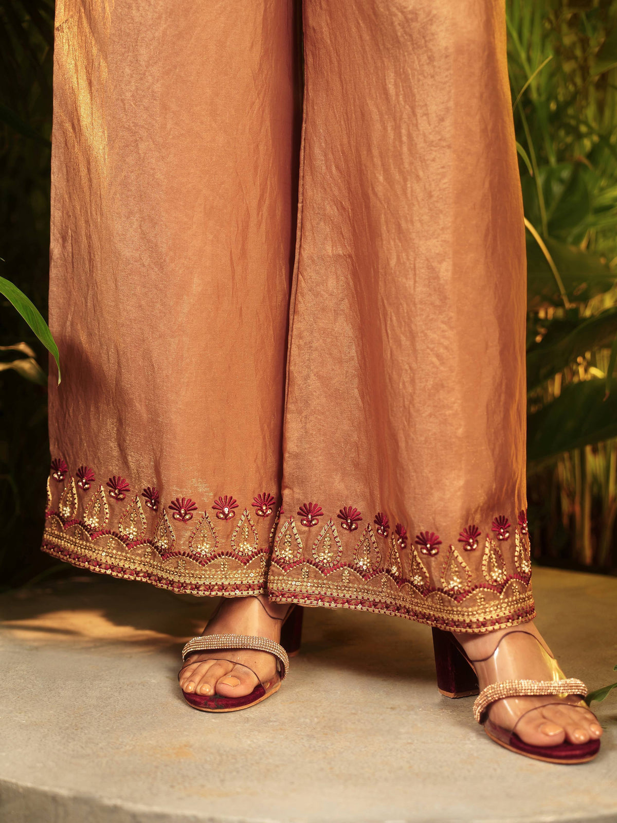 Elegant ethnic palazzo pants with gold and maroon embroidery, paired with embellished heels.