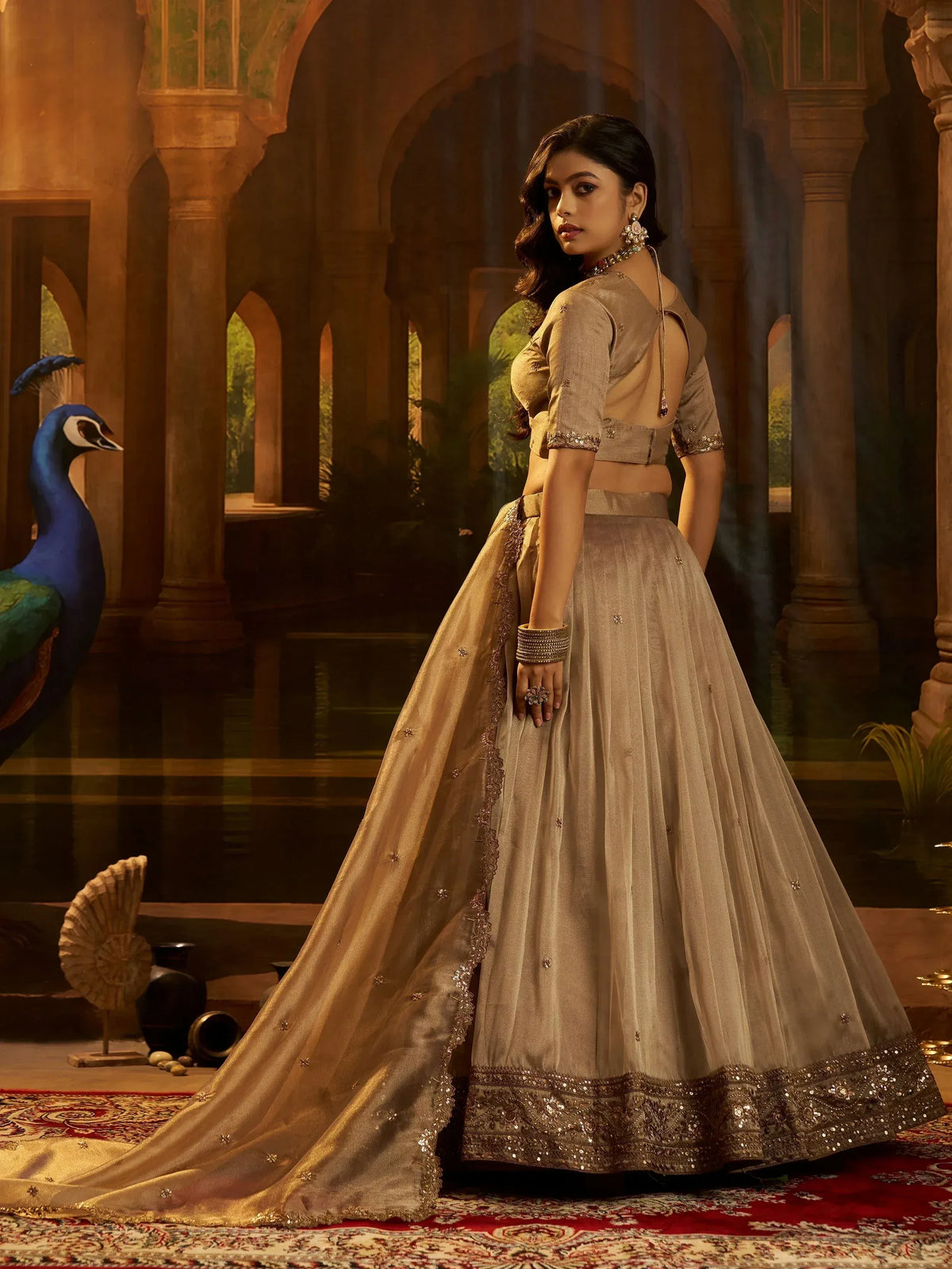 Elegant beige lehenga choli with gold embroidery, perfect for Indian weddings and festive occasions.