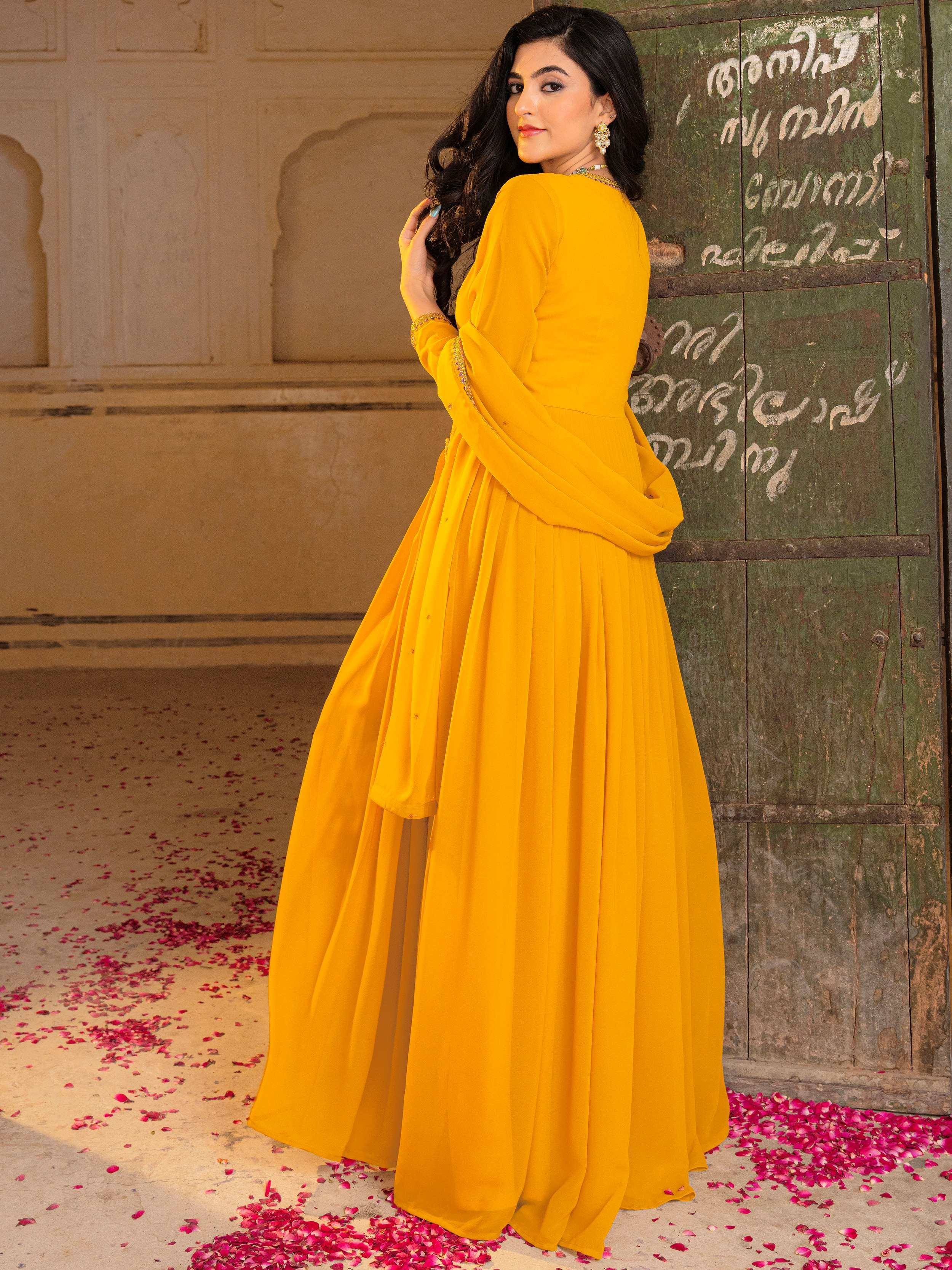 Vibrant yellow ethnic gown with pleated skirt, perfect for Indian celebrations and festive occasions.
