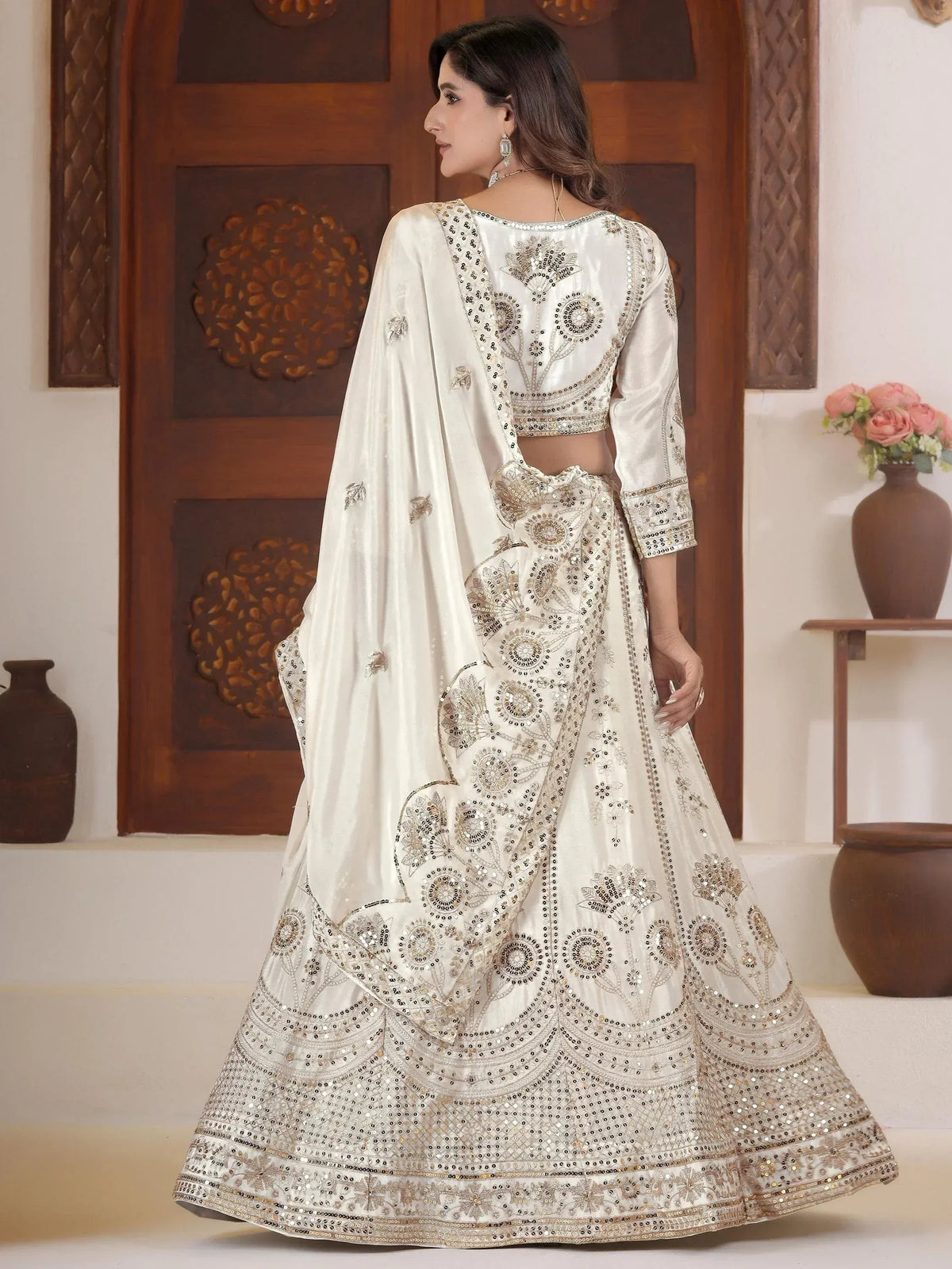 Elegant white lehenga choli with gold mirror work, perfect for Indian weddings and festive occasions.