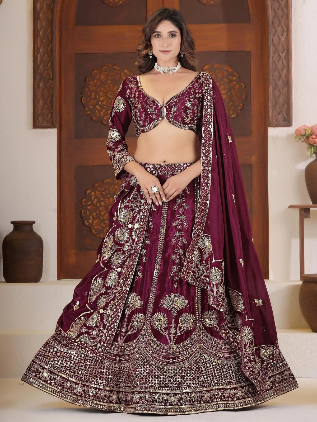 Maroon designer lehenga choli with gold embroidery and mirror work, perfect for Indian weddings and festive occasions.
