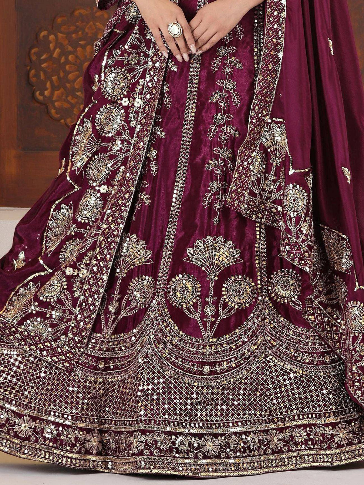 Luxury maroon lehenga choli with intricate gold embroidery and mirror work, perfect for Indian weddings and festive occasions.