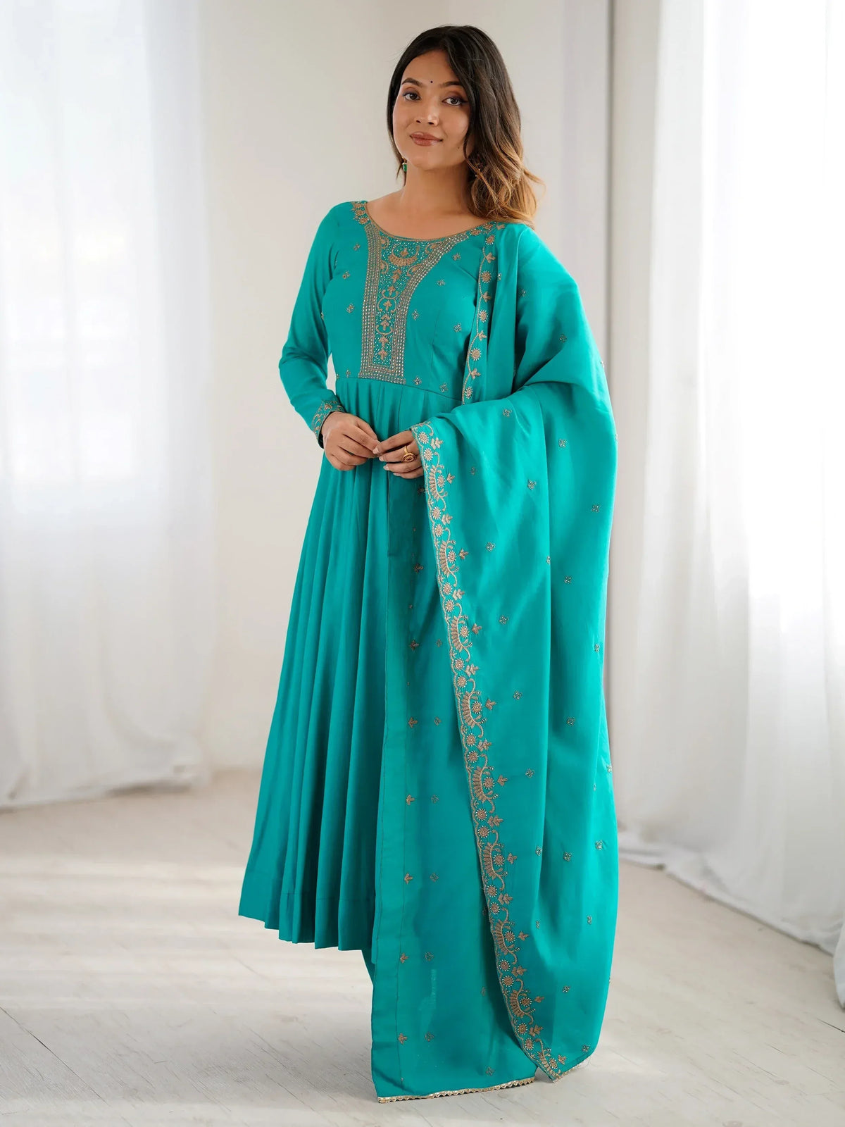 Teal ethnic gown with gold embroidery, perfect for Indian festive occasions