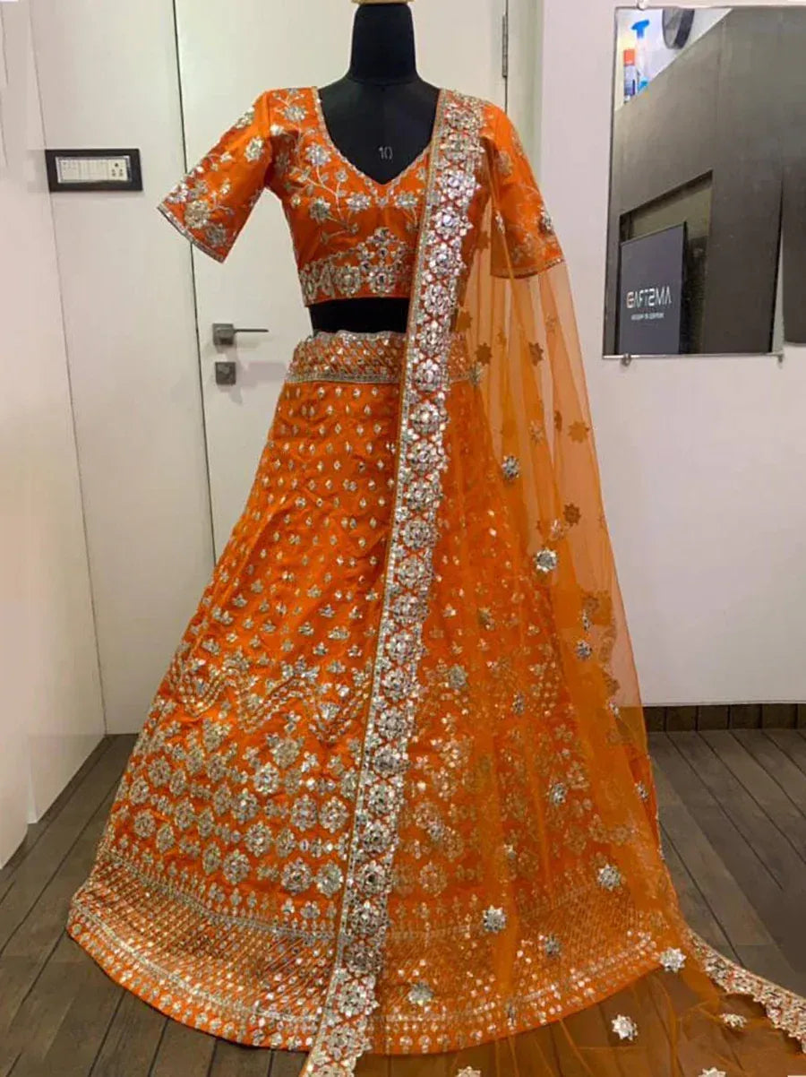 Orange designer lehenga choli with heavy silver embroidery and net dupatta, perfect for weddings and festive occasions