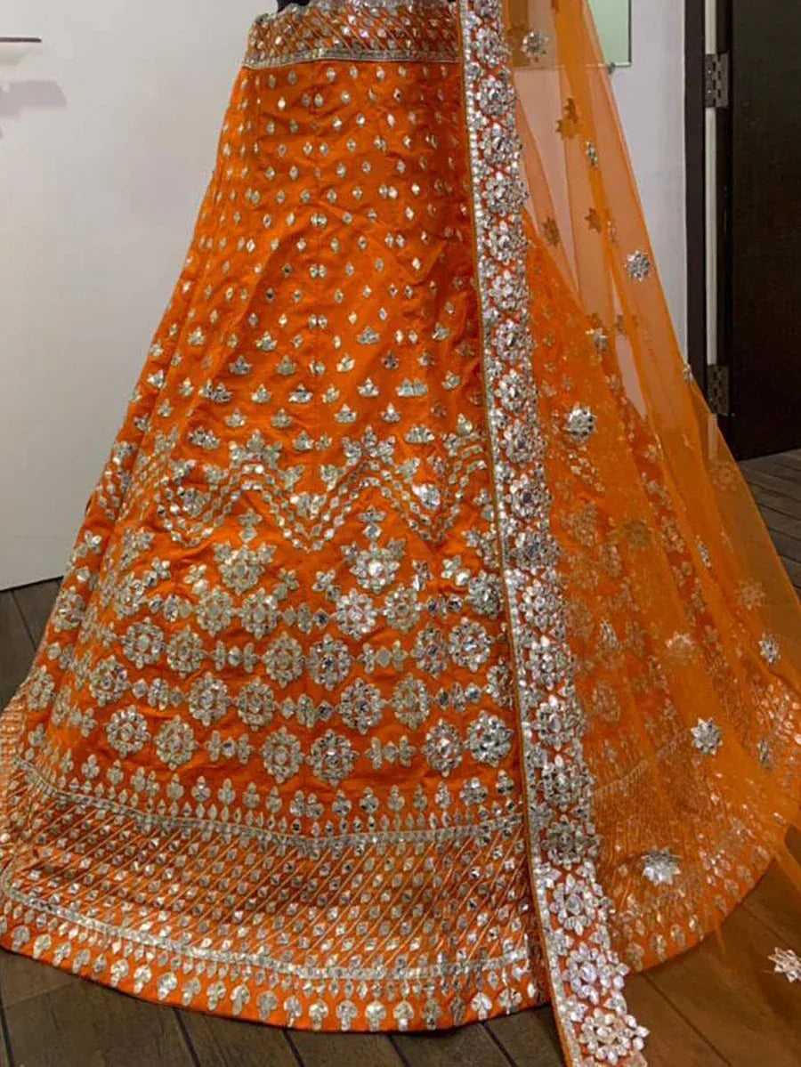 Orange designer lehenga choli with heavy silver embroidery and sequin work, perfect for weddings and festivals