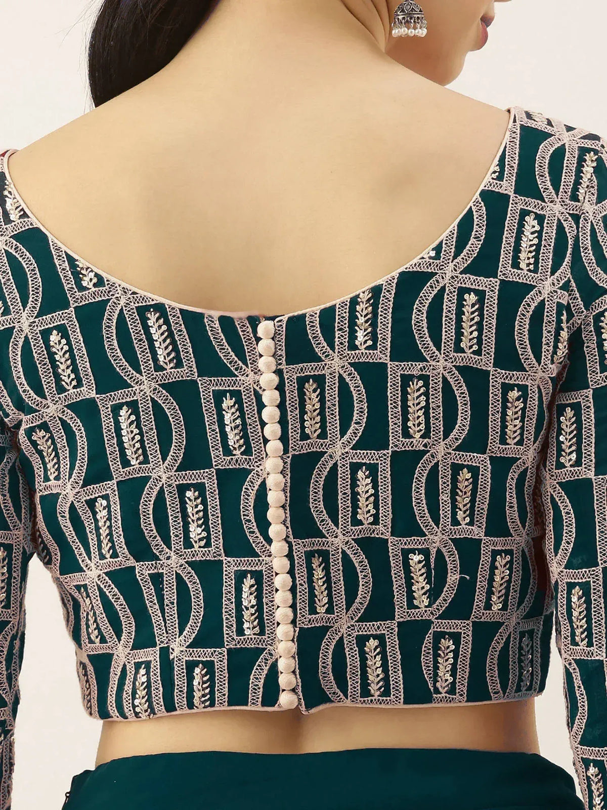 Emerald green embroidered blouse with geometric patterns and back button detail, perfect for Indian ethnic wear.