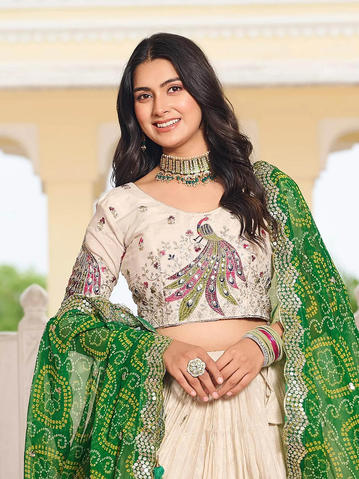 Woman in cream peacock-embroidered lehenga choli with green dupatta, ethnic Indian wear