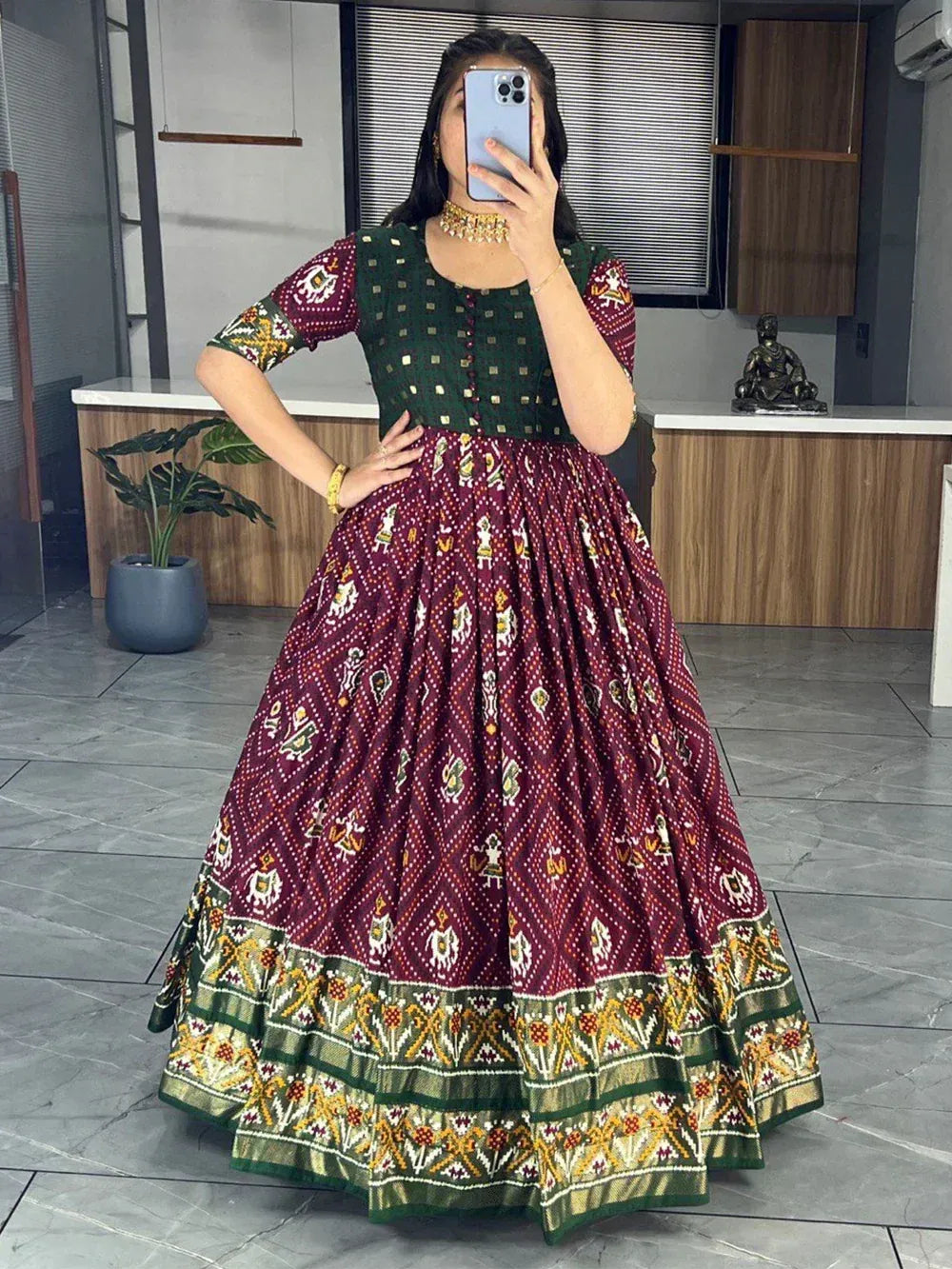 Woman wearing maroon and green Bandhani Anarkali gown with traditional ethnic patterns