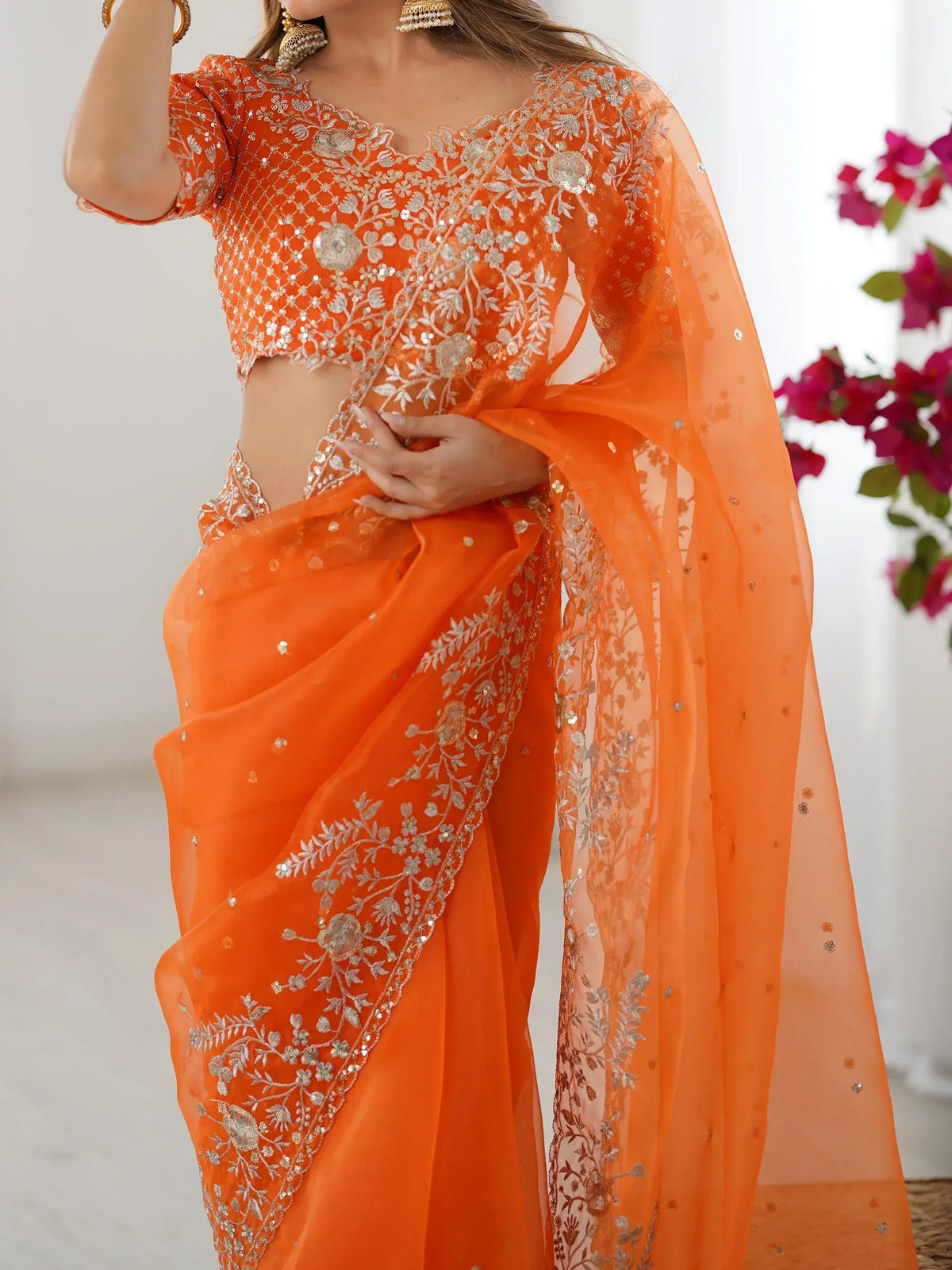 Orange embroidered saree with floral zari work and matching blouse, perfect for Indian ethnic occasions
