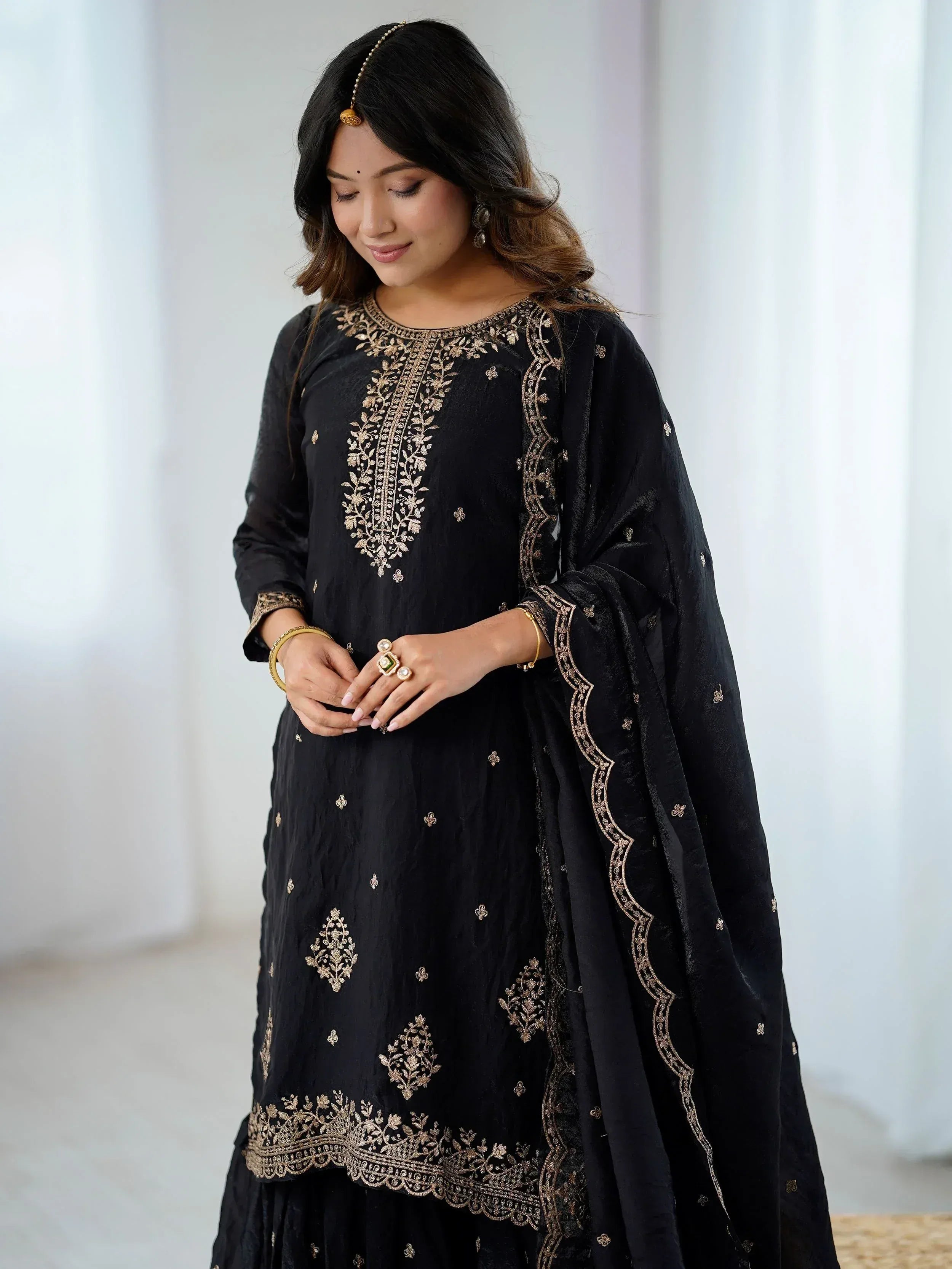Black embroidered salwar kameez with gold detailing, perfect for ethnic wear occasions