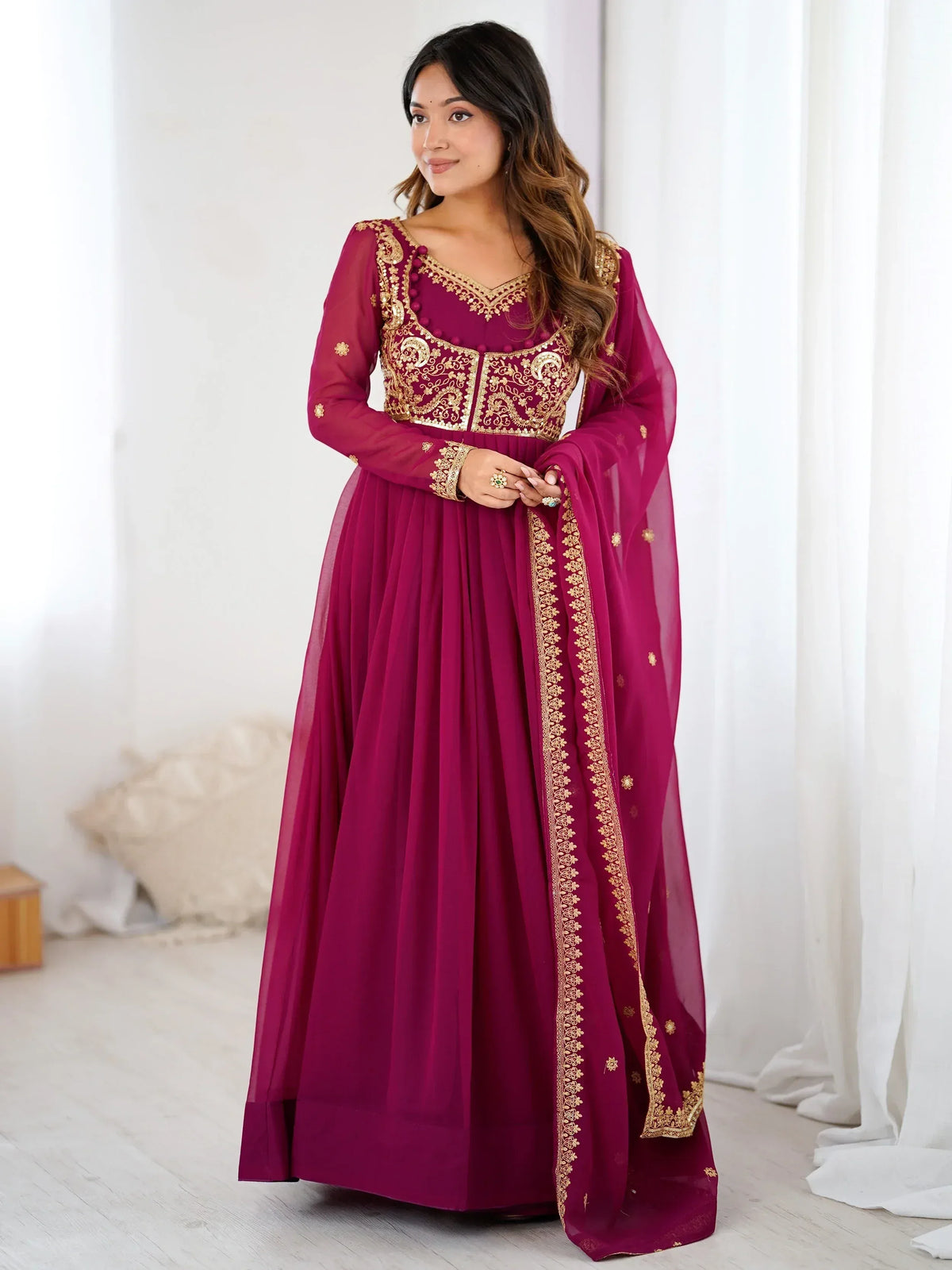 Magenta ethnic gown with gold embroidery, perfect for Indian weddings or festive occasions.