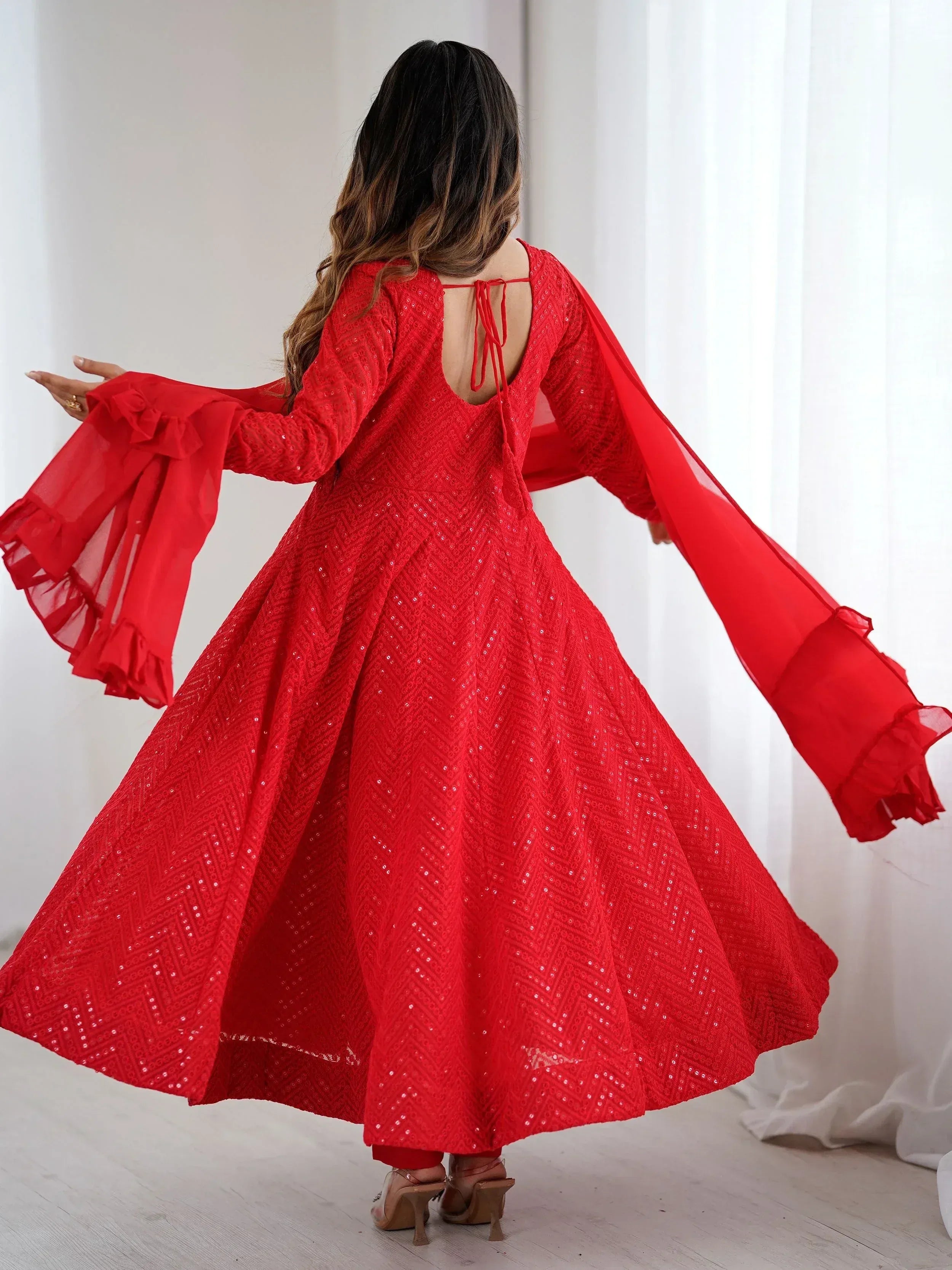 Red sequin ethnic gown with flared sleeves and back tie, perfect for festive occasions.