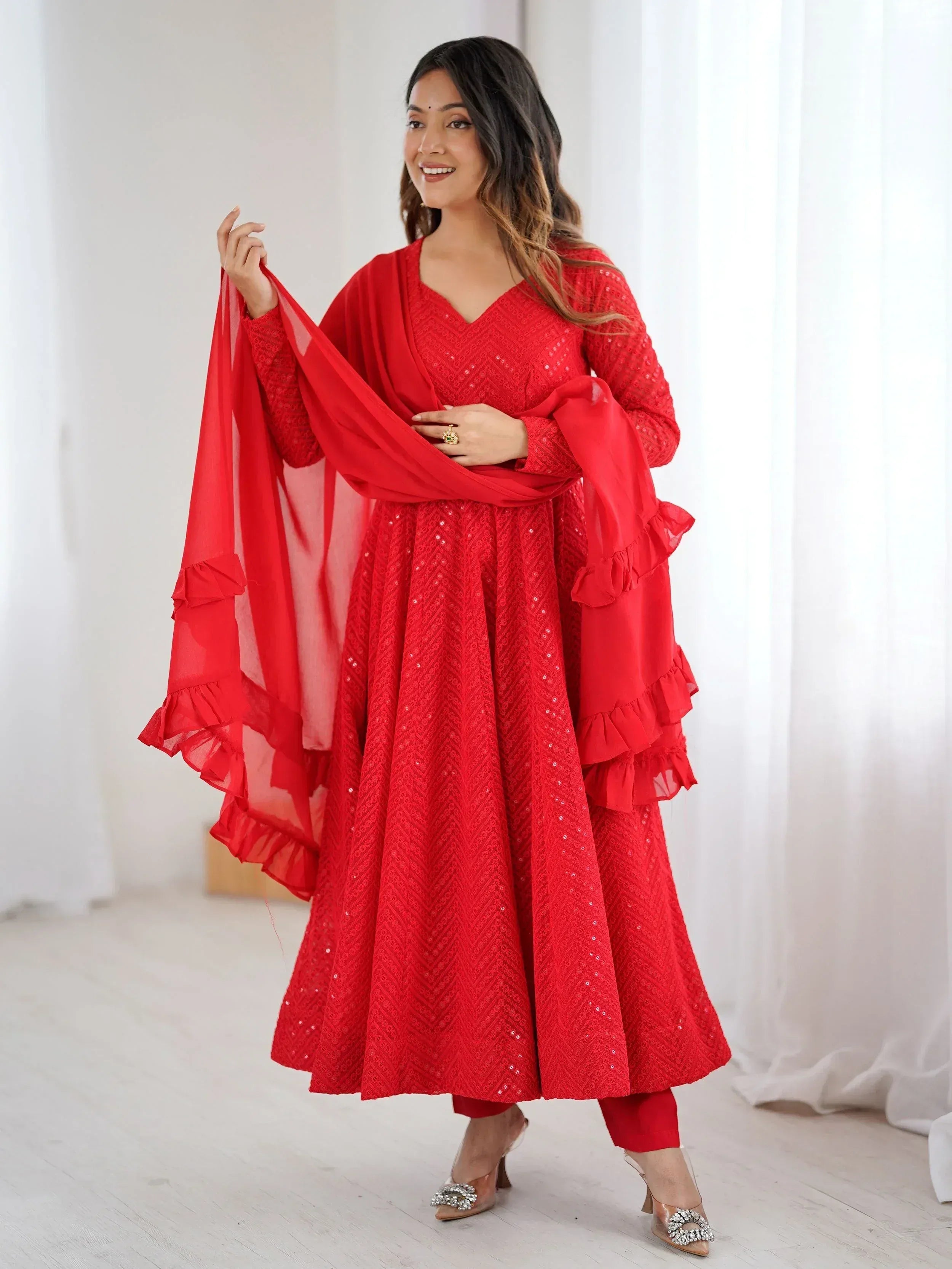 Red ethnic gown with ruffled dupatta and sequin detailing for festive occasions