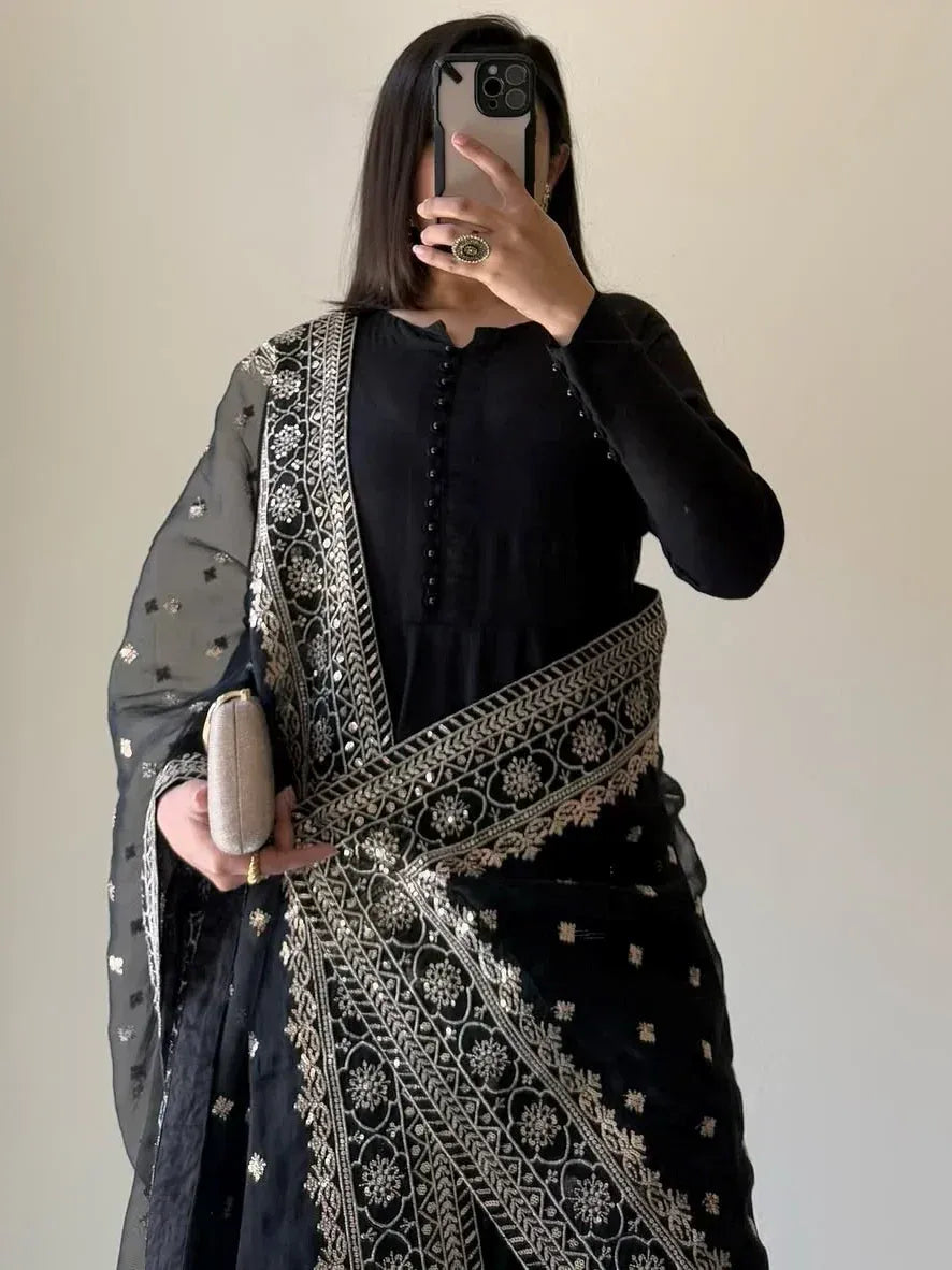 Black embroidered saree with gold detailing, paired with matching blouse and clutch, ideal for ethnic occasions.