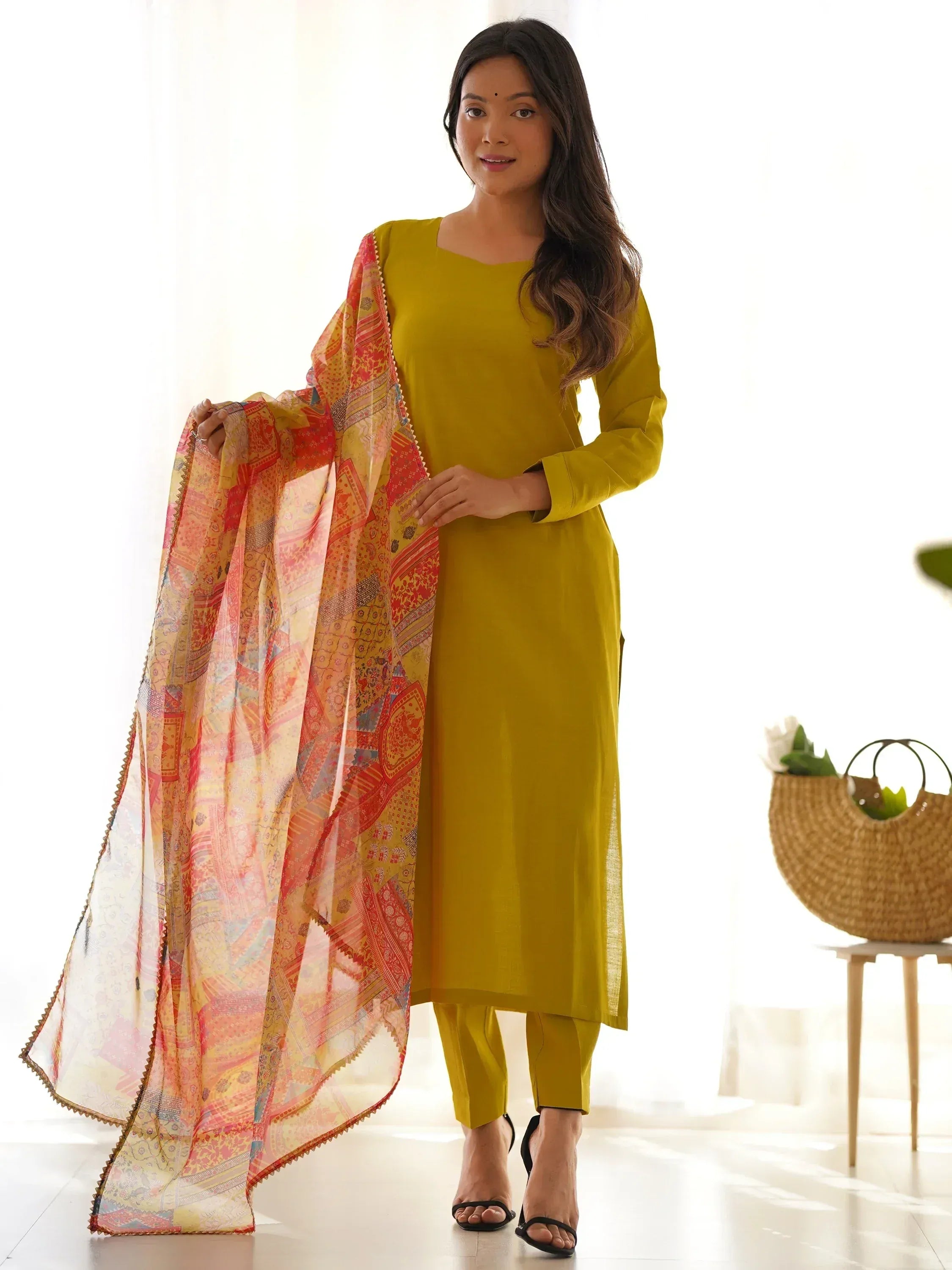Woman wearing yellow straight cut salwar kameez with printed multicolor dupatta