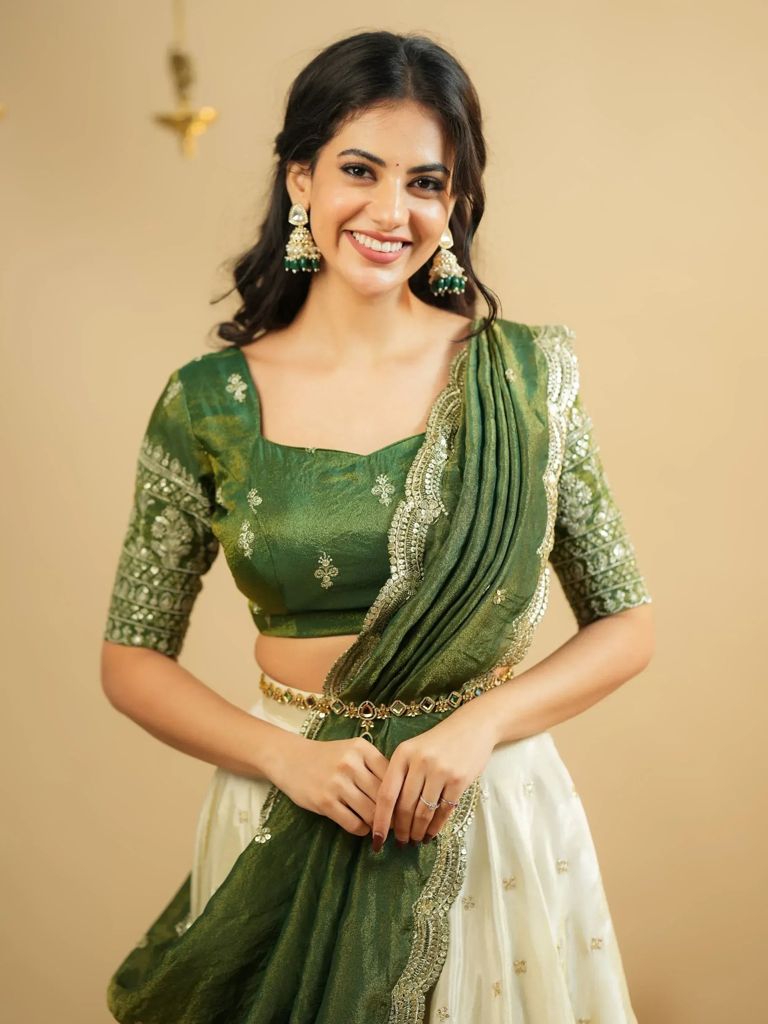 Green and white designer lehenga choli with gold embroidery and matching earrings
