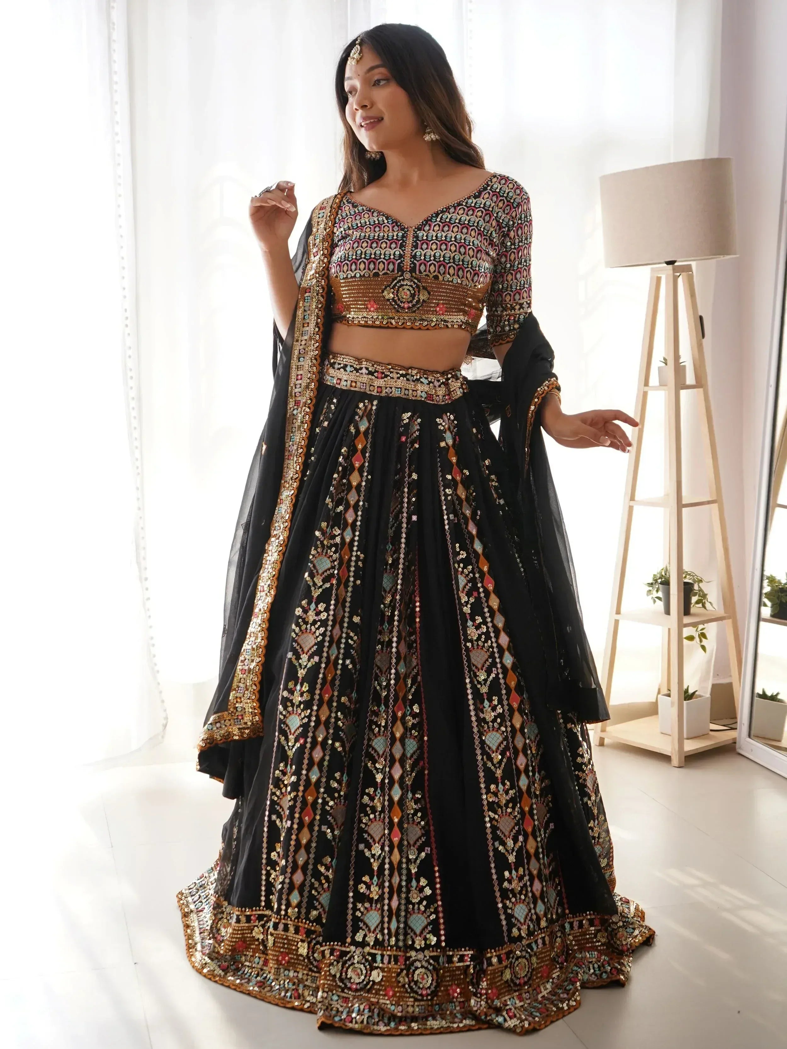 Black embroidered lehenga choli with colorful mirror work, perfect for Indian ethnic wear occasions.
