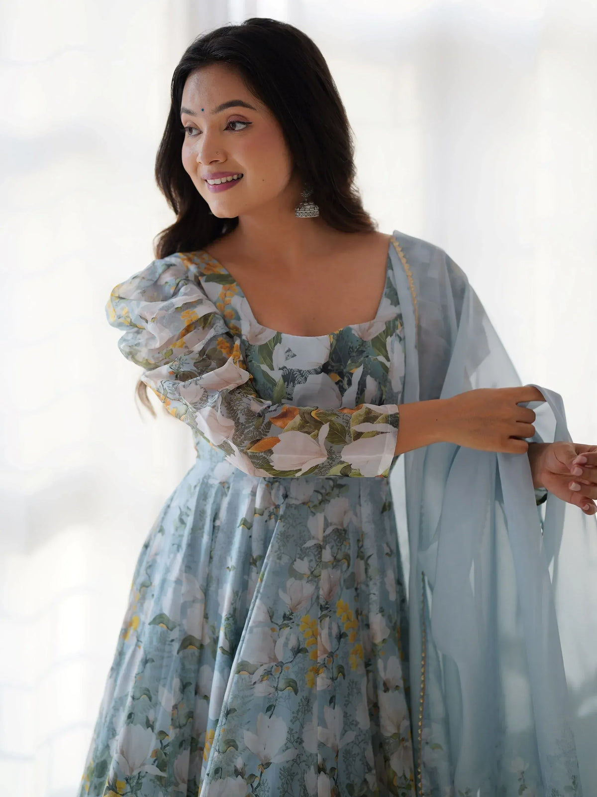 Woman in floral print ethnic gown with puff sleeves and dupatta, perfect for Indian occasions