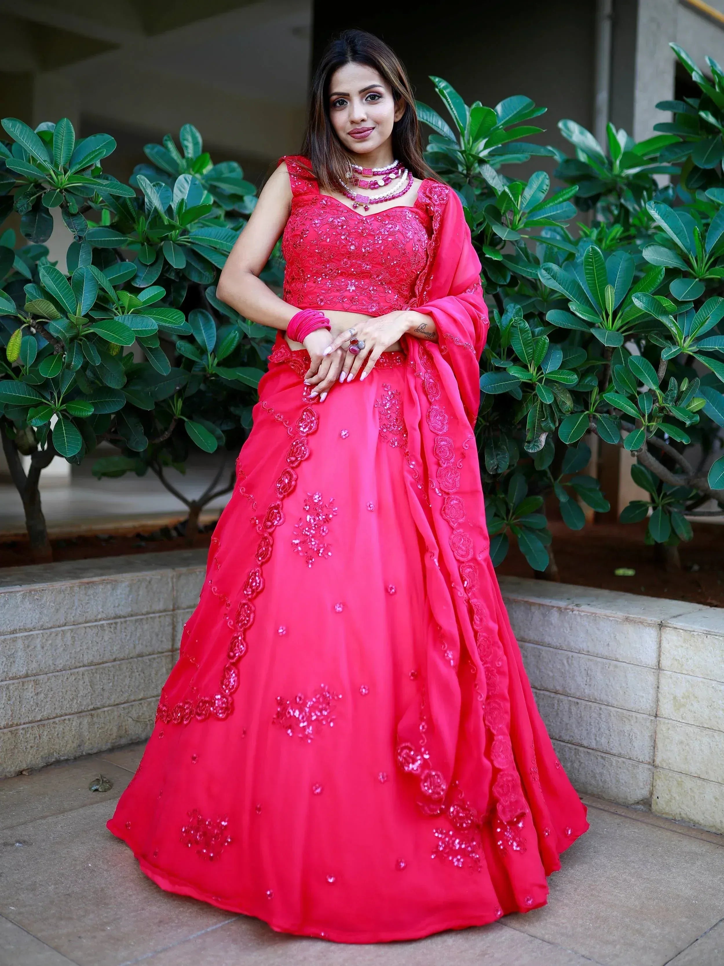 Vibrant red designer lehenga choli with floral embroidery, perfect for Indian weddings and festive occasions.