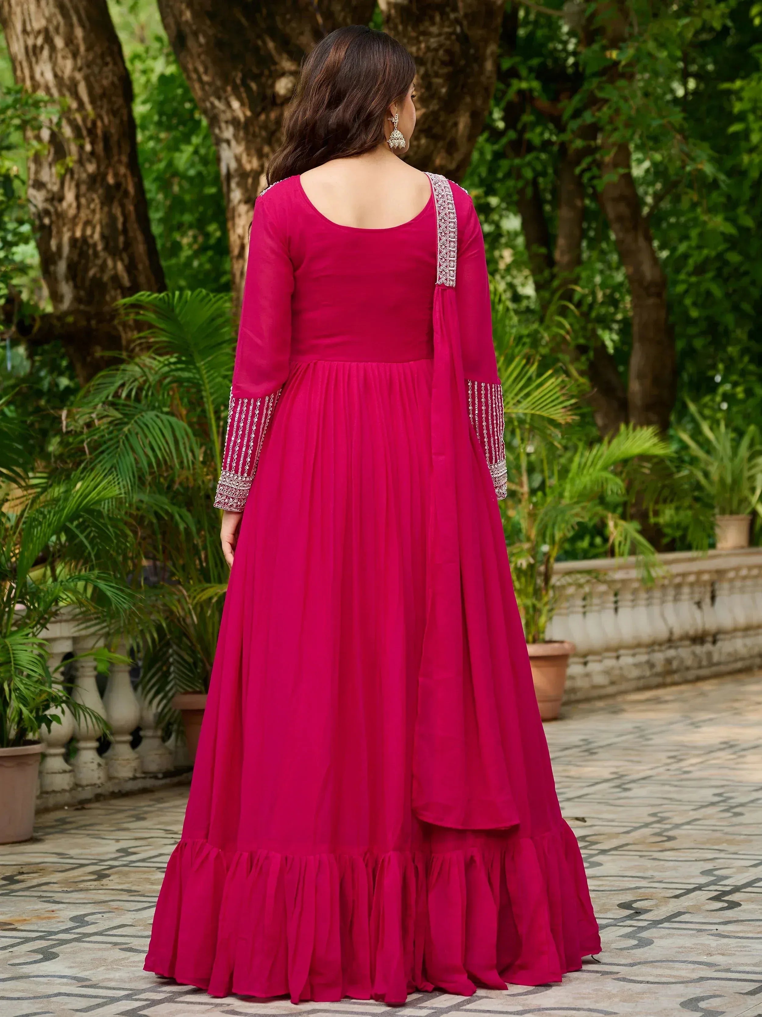 Pink ethnic gown with embroidered sleeves and ruffled hem, perfect for Indian occasions