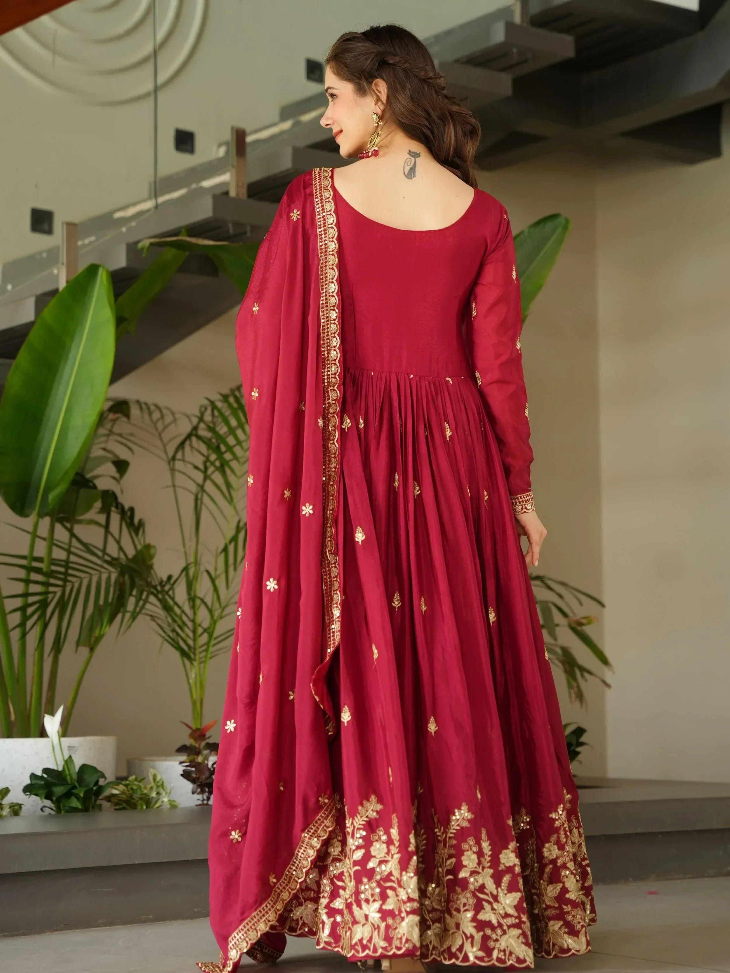 Maroon ethnic gown with gold embroidery and floral dupatta, perfect for Indian occasions