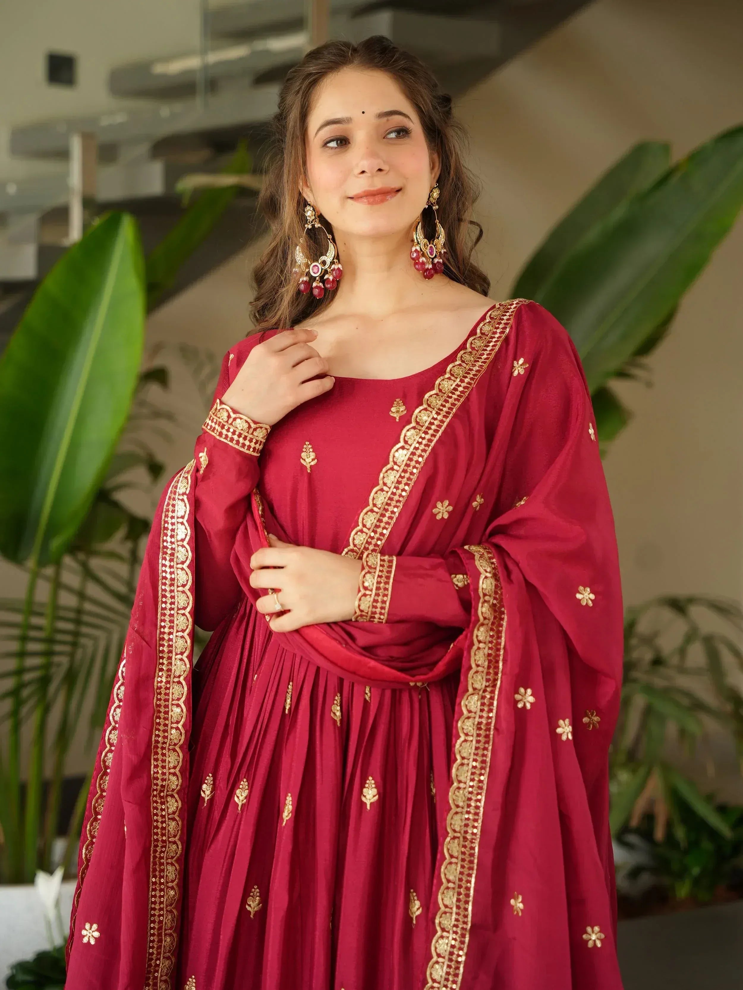 Maroon ethnic gown with gold embroidery, perfect for Indian weddings or festive occasions