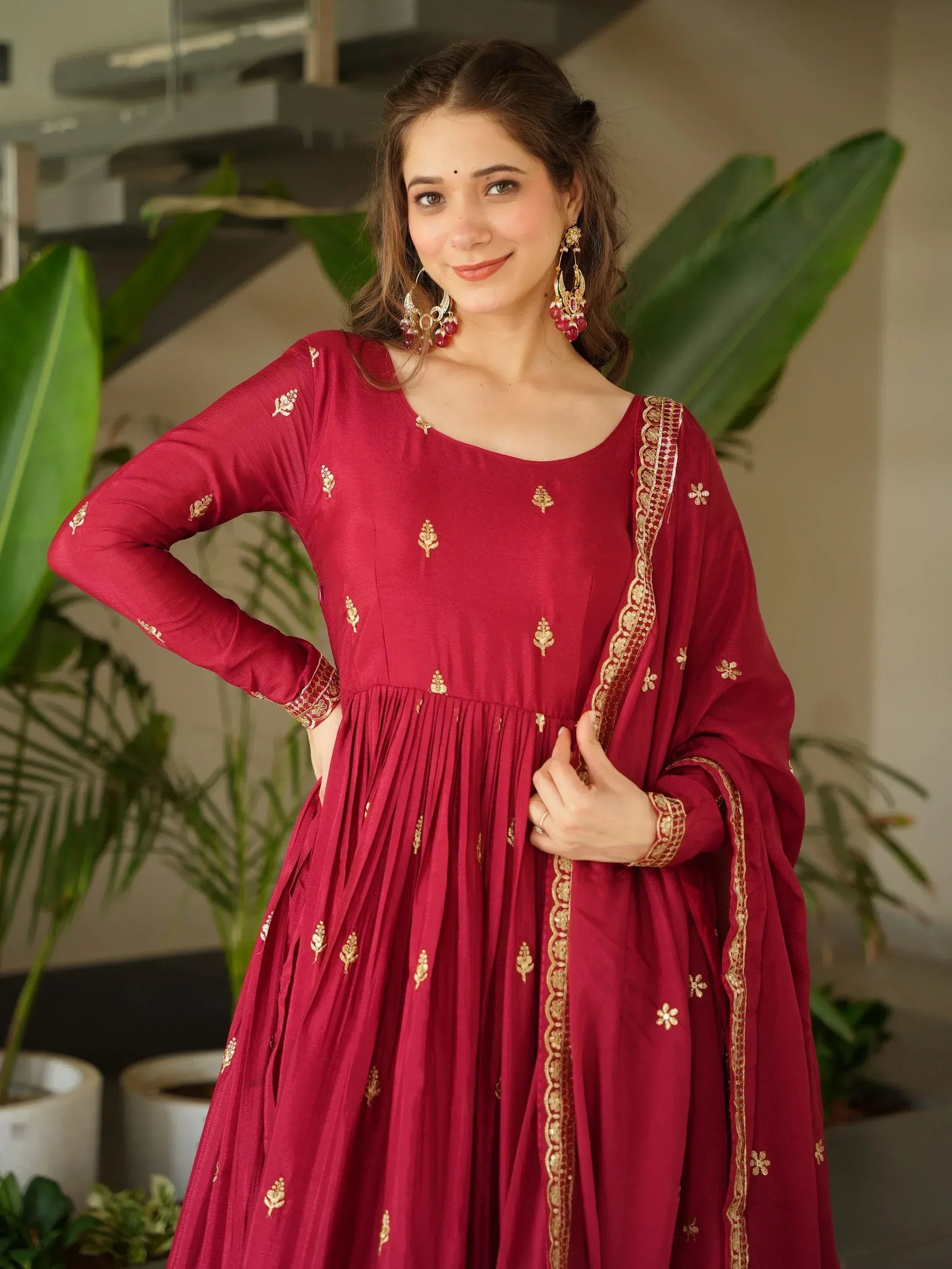 Maroon ethnic gown with gold embroidery, perfect for Indian occasions and festive wear.