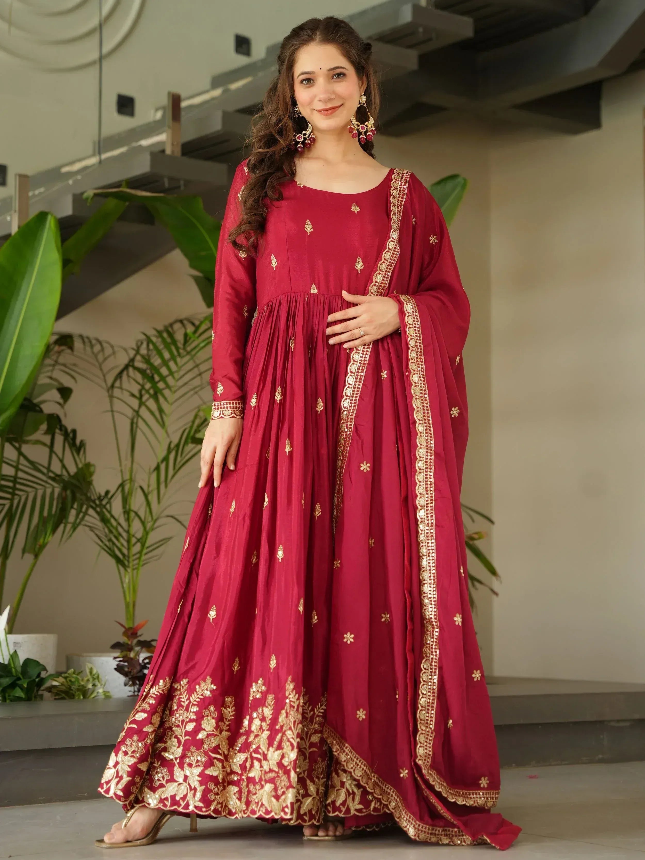 Maroon ethnic anarkali gown with gold embroidery, perfect for Indian weddings and festive occasions.