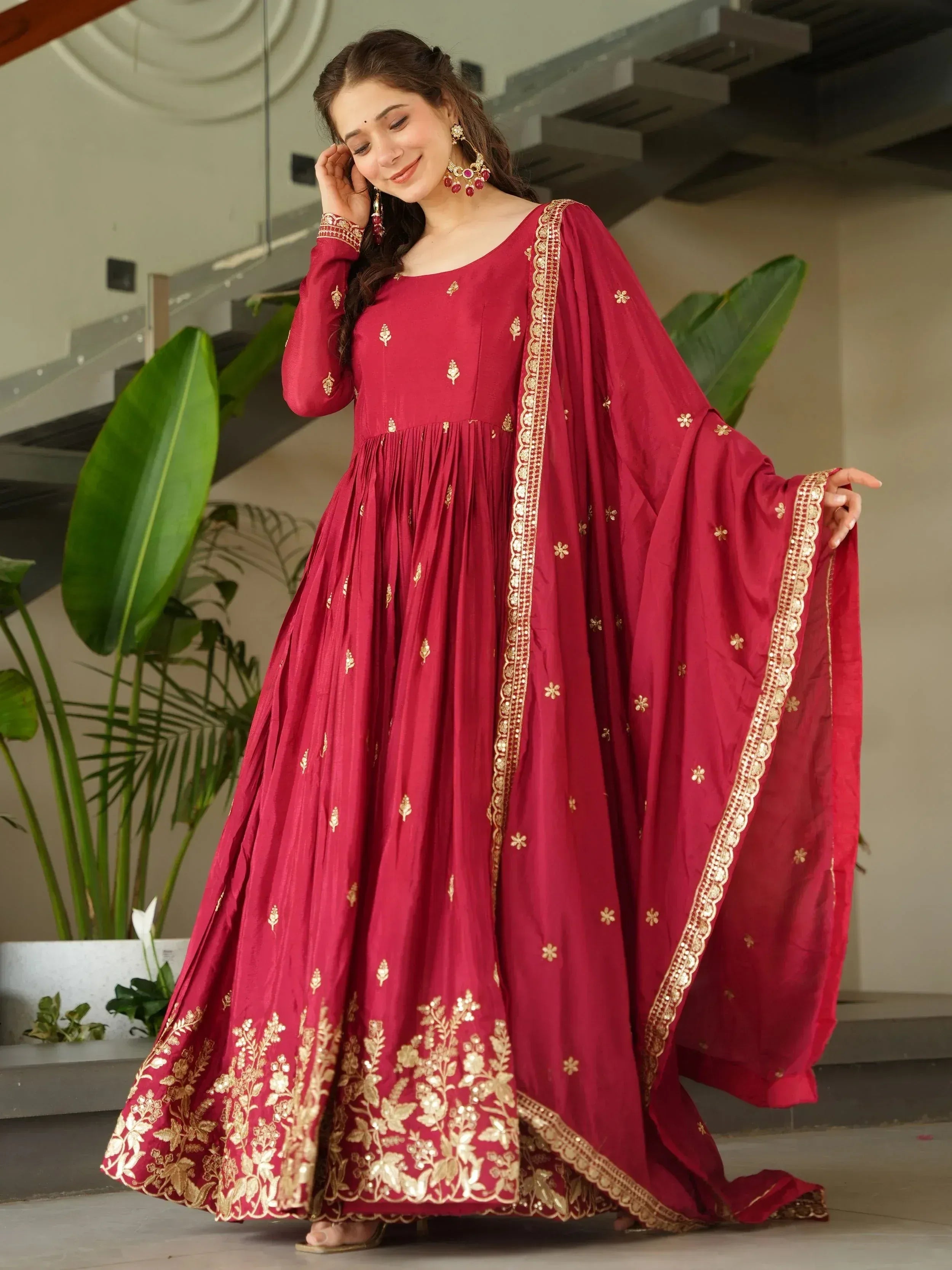 Maroon ethnic gown with gold embroidery, perfect for Indian celebrations and festive occasions.