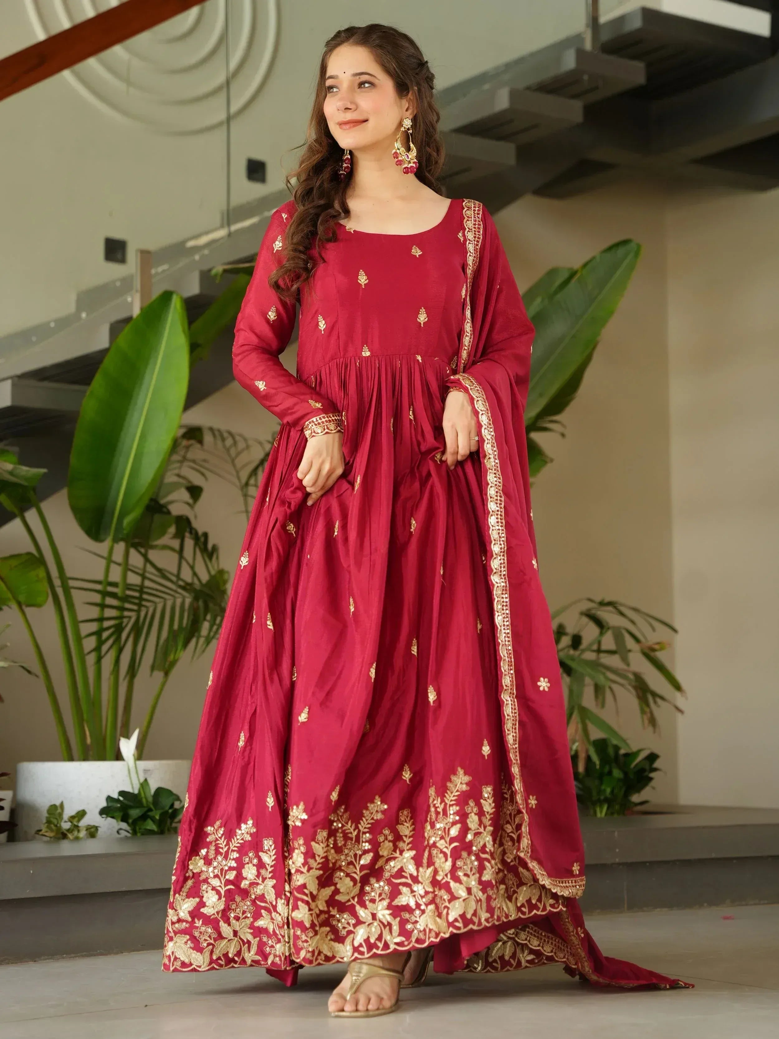 Maroon ethnic gown with gold embroidery, perfect for Indian occasions and festive wear.