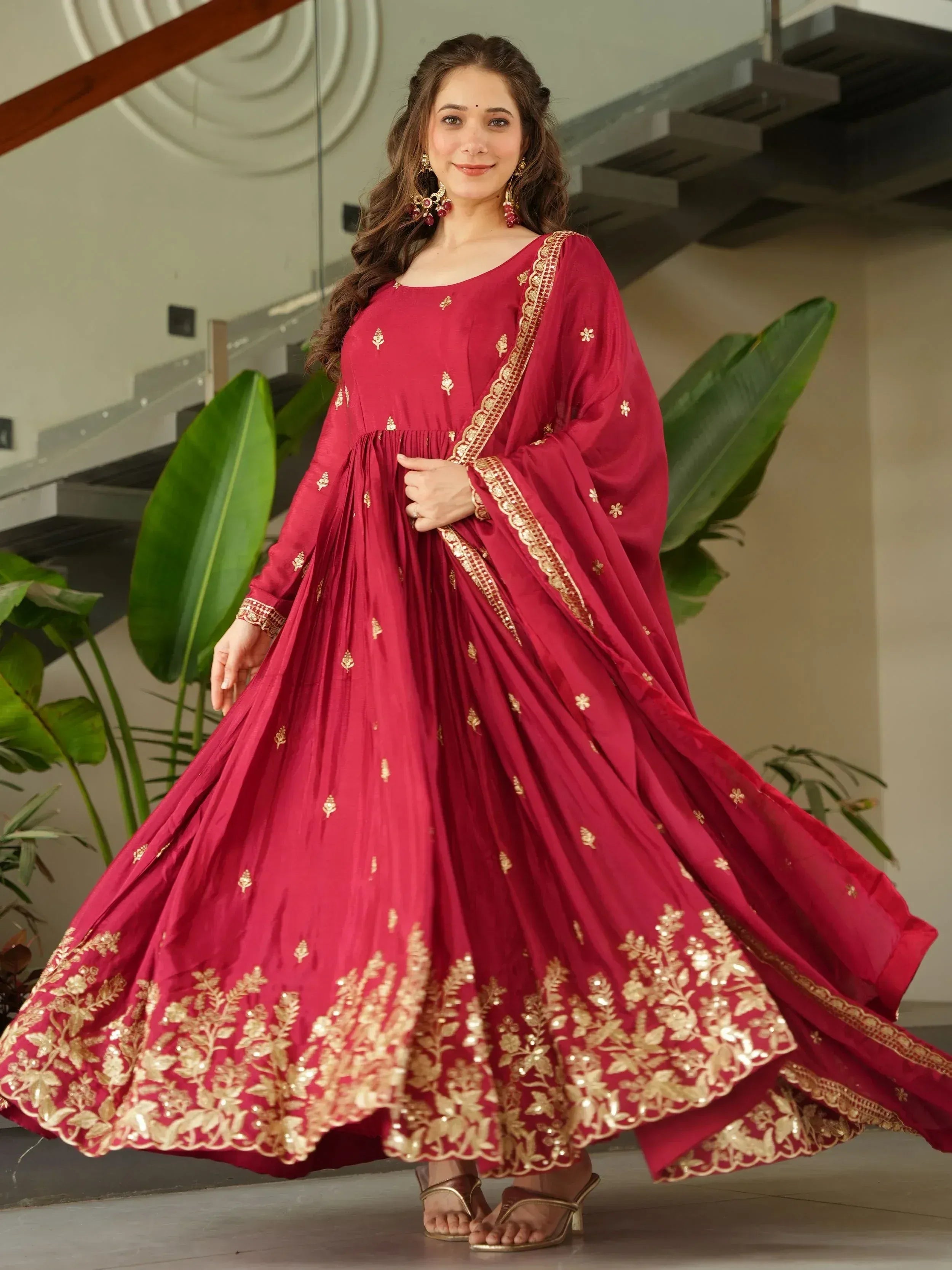 Red ethnic gown with gold embroidery, perfect for Indian celebrations and festive occasions.