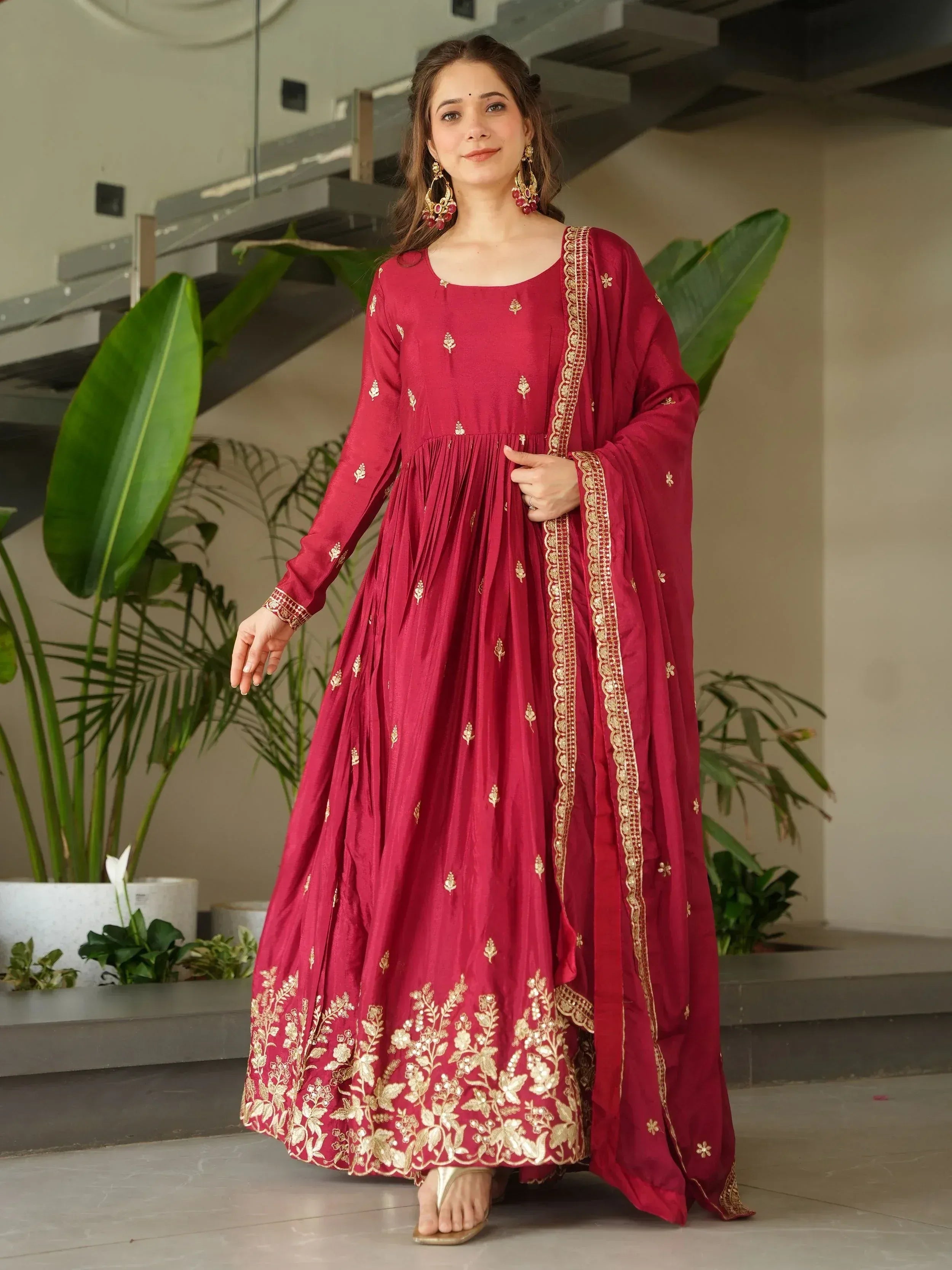 Maroon ethnic gown with gold embroidery, perfect for Indian occasions and festive wear.