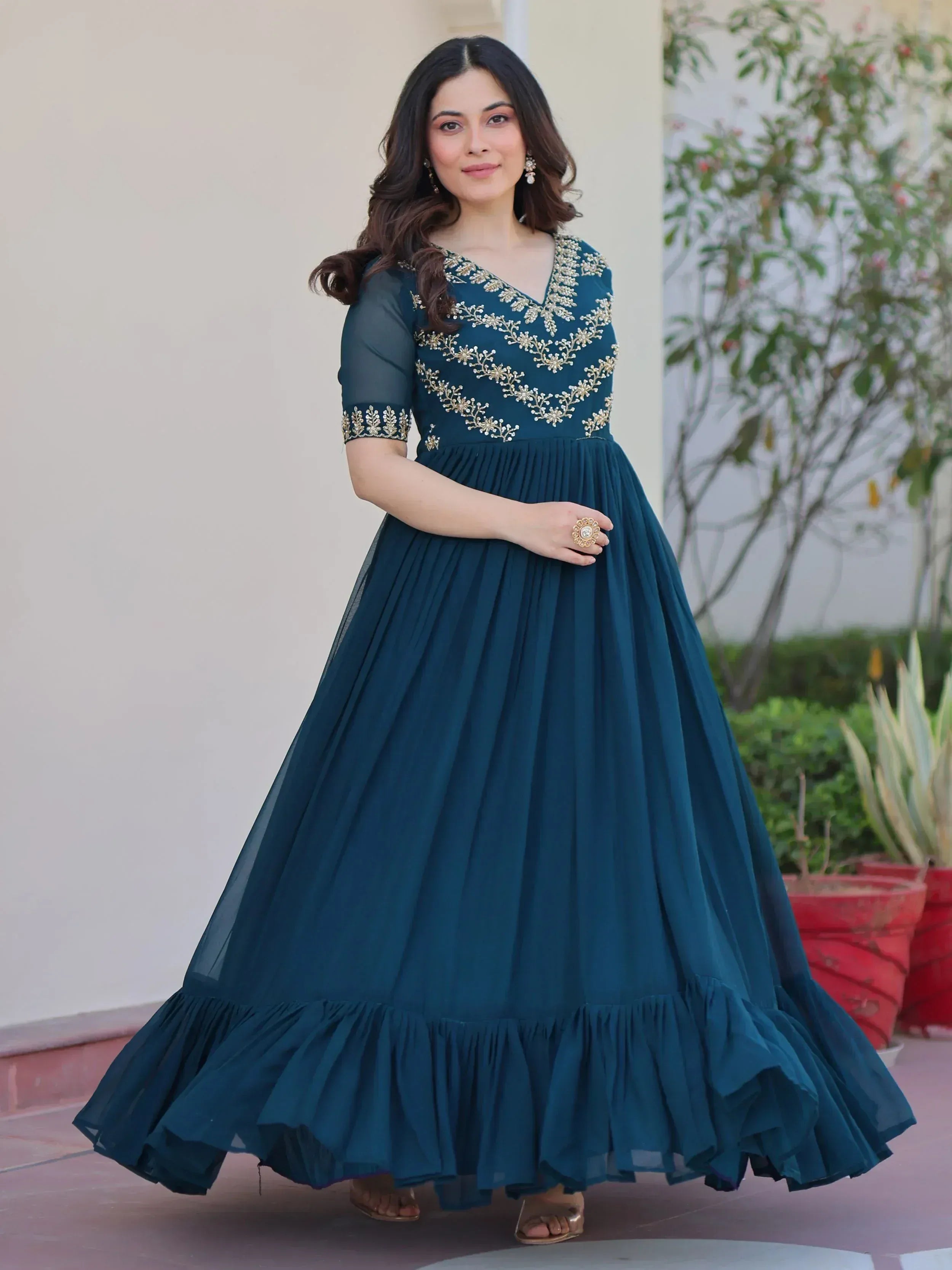 Teal ethnic gown with gold embroidery, pleated skirt, and ruffle hem for women's festive wear