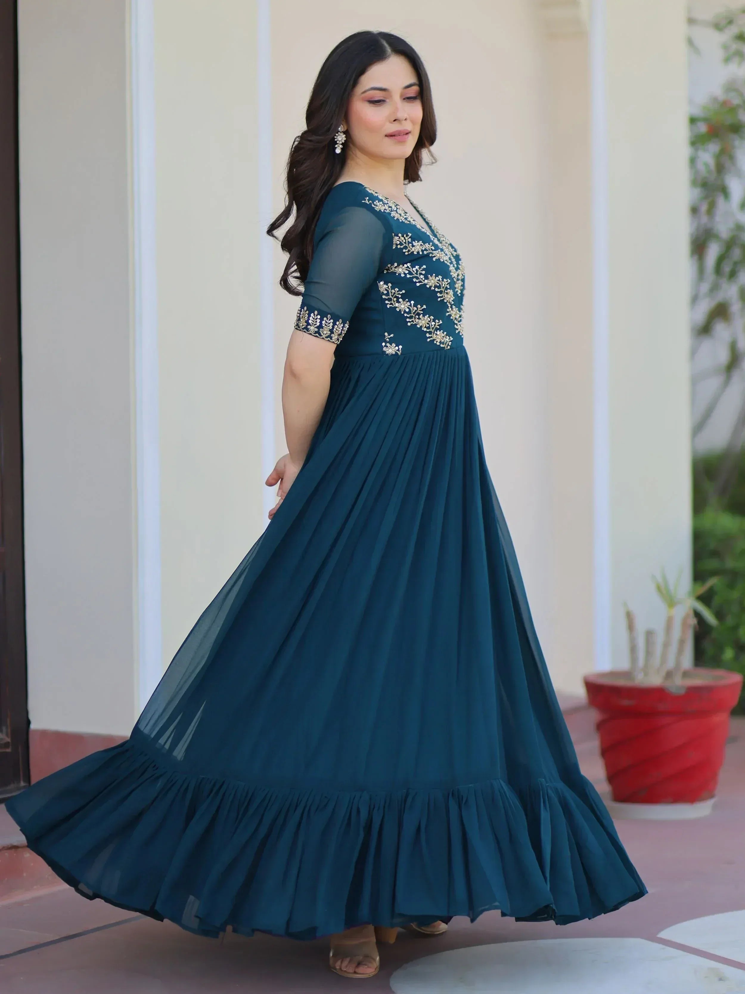 Teal ethnic gown with gold embroidery, pleated skirt, and sheer sleeves for women's festive wear