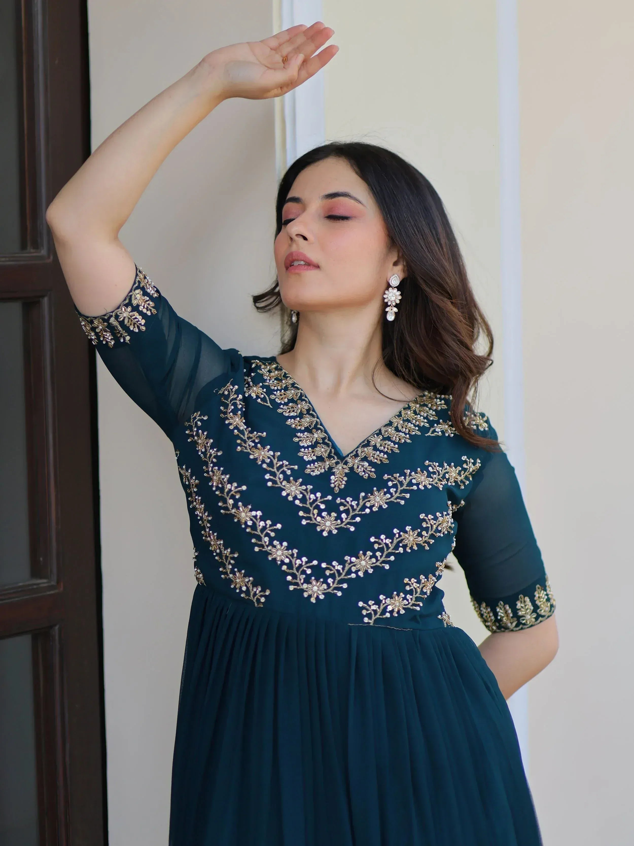 Woman in teal ethnic gown with gold floral embroidery, perfect for Indian occasions