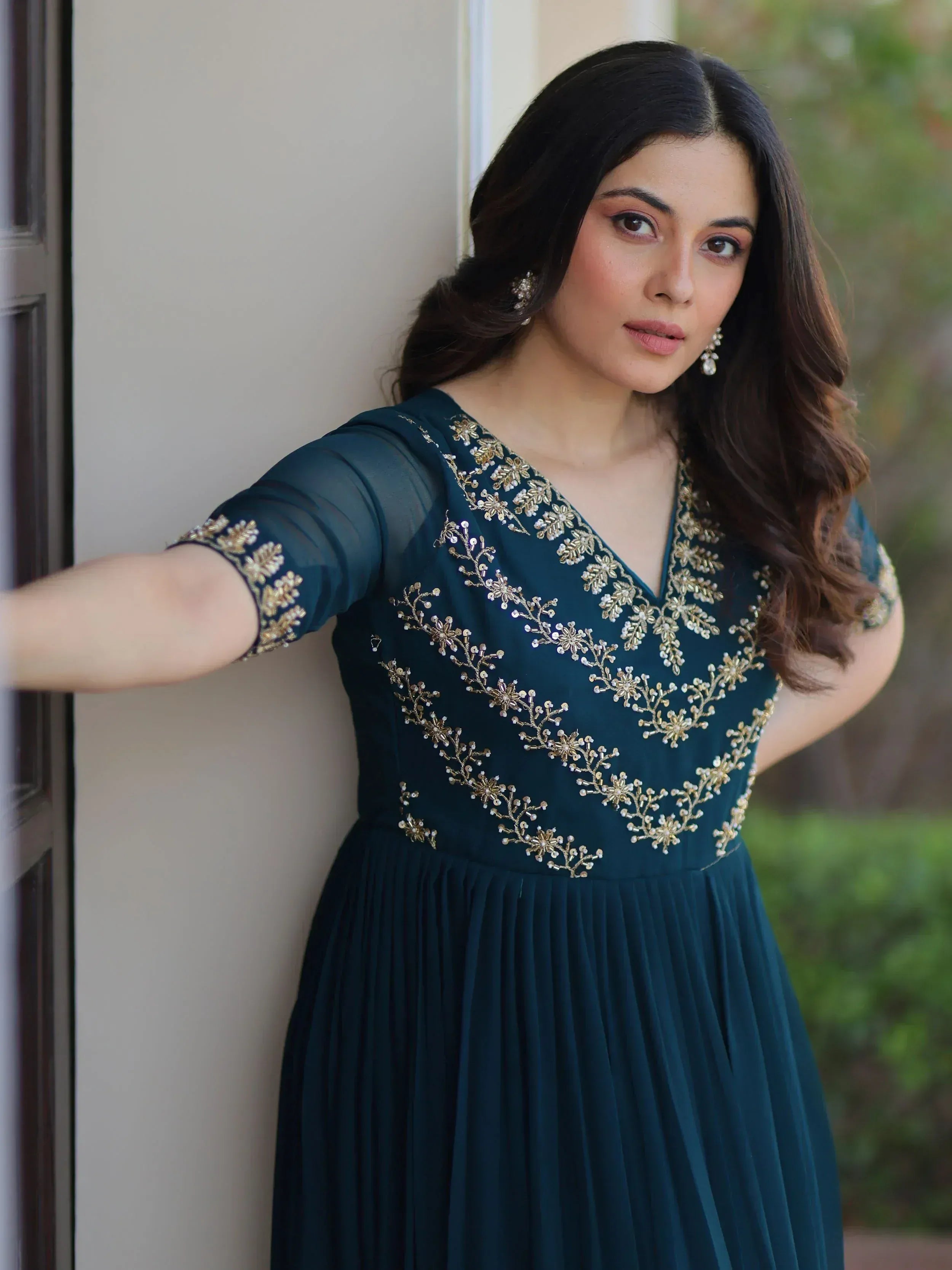 Elegant teal ethnic gown with gold floral embroidery and sheer sleeves, perfect for Indian occasions.