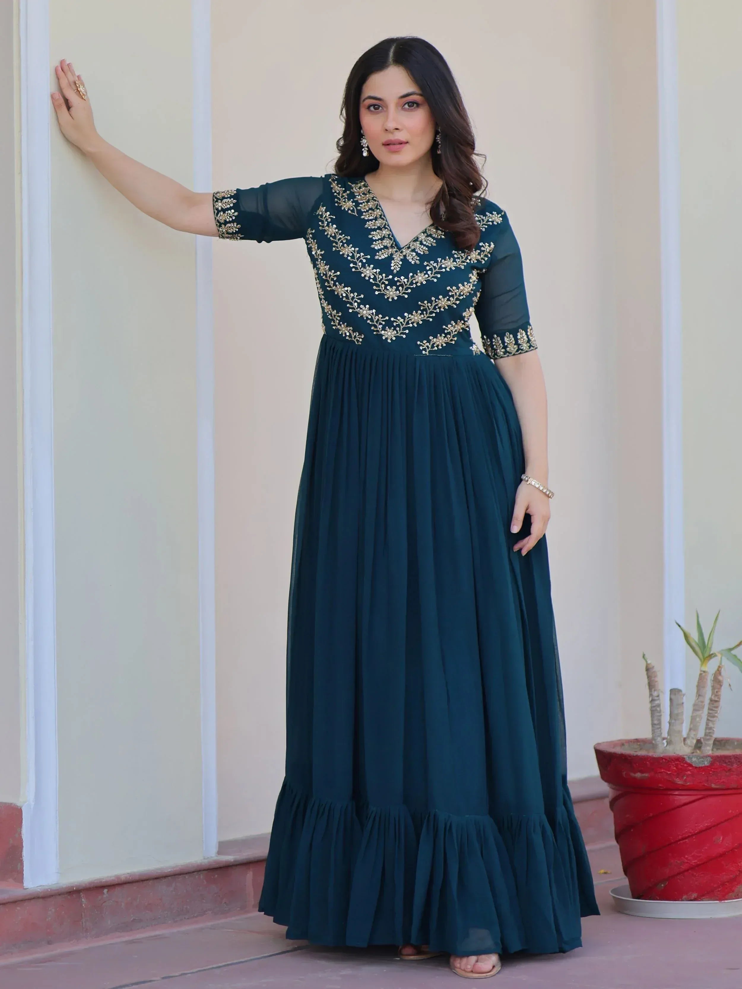 Teal ethnic gown with gold embroidery, V-neck, sheer sleeves, and pleated skirt for Indian occasions