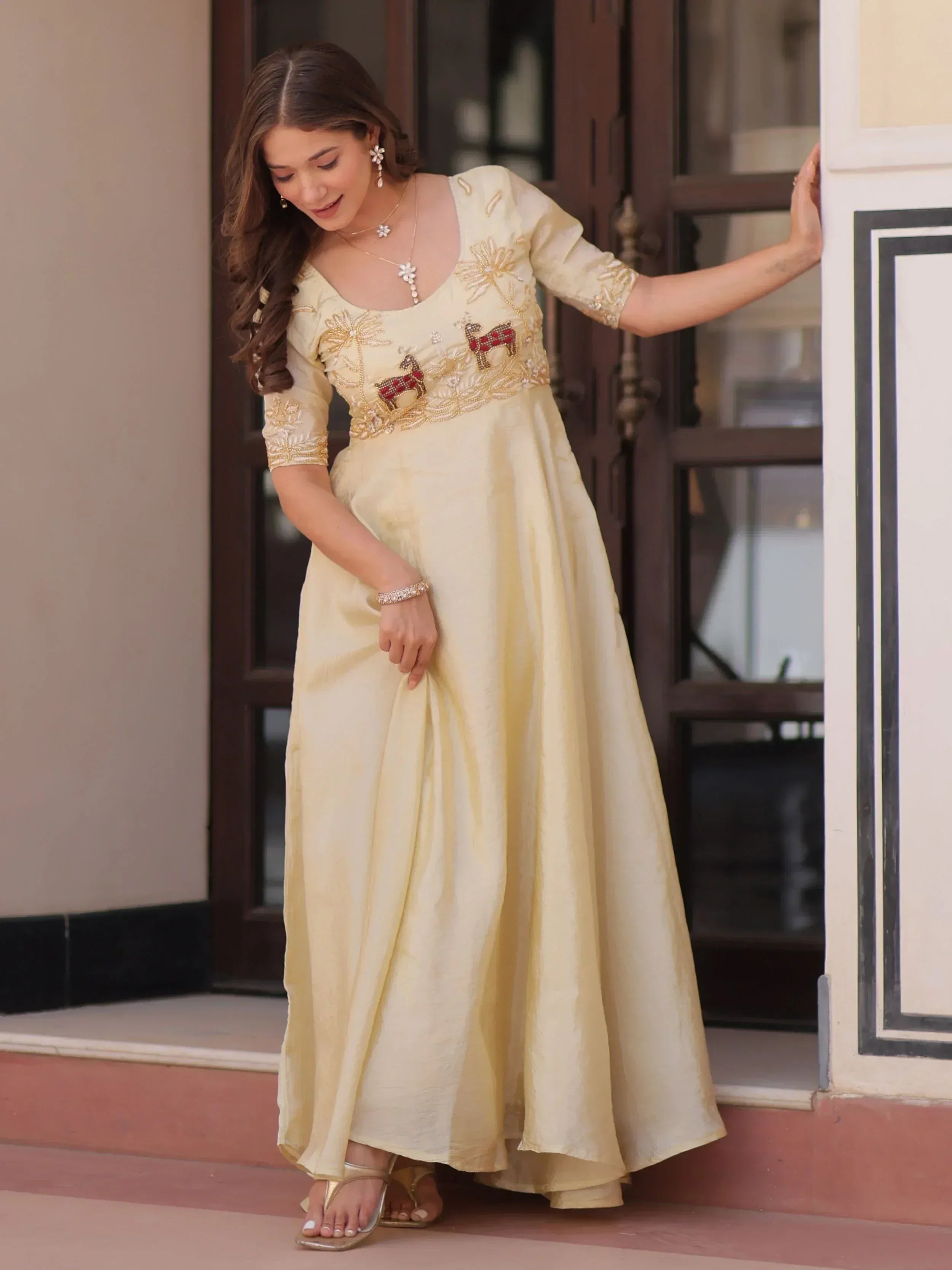 Cream ethnic gown with deer embroidery, perfect for Indian occasions and festive wear.