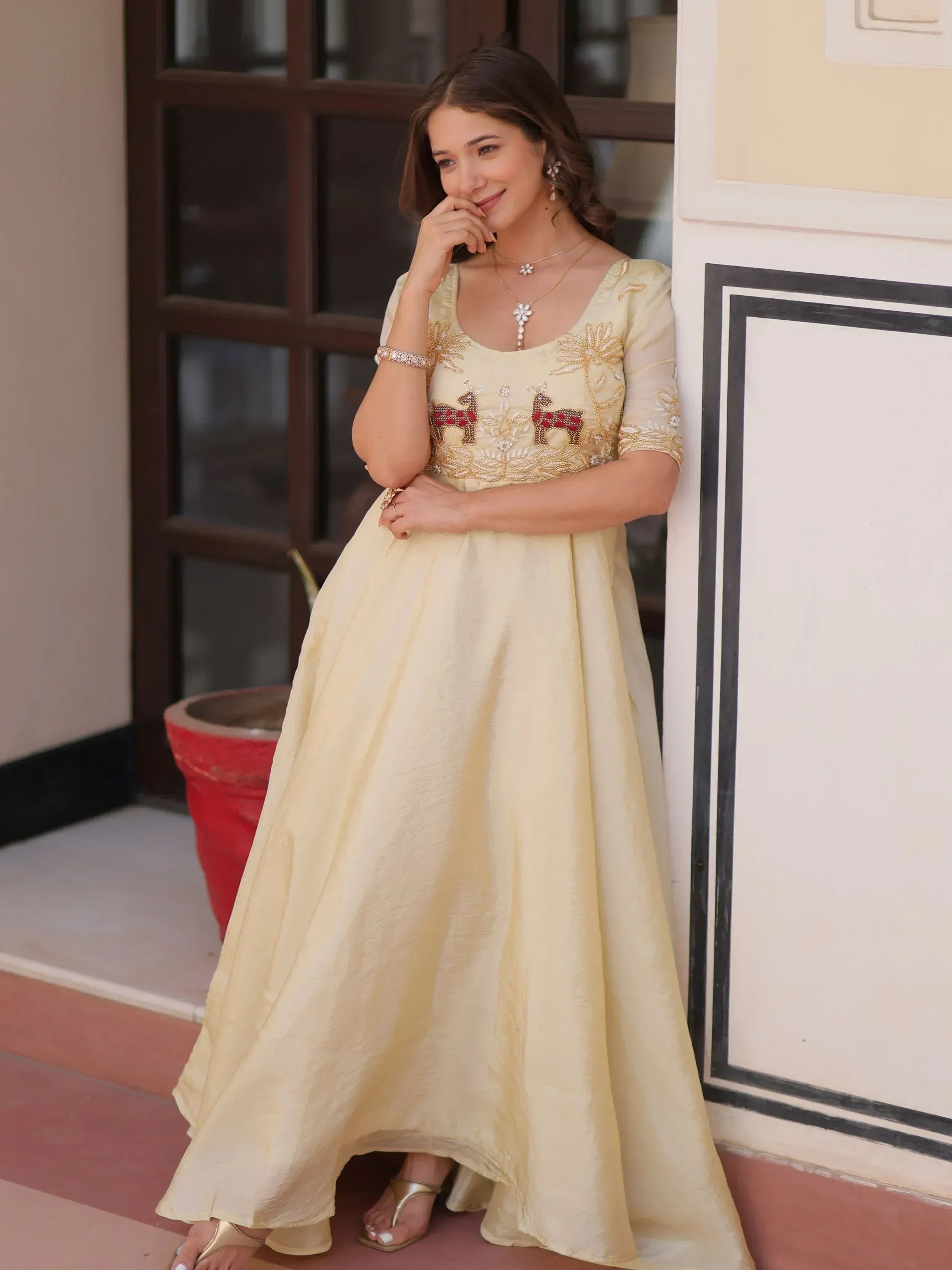 Elegant cream ethnic gown with deer embroidery, perfect for Indian celebrations and festive occasions.