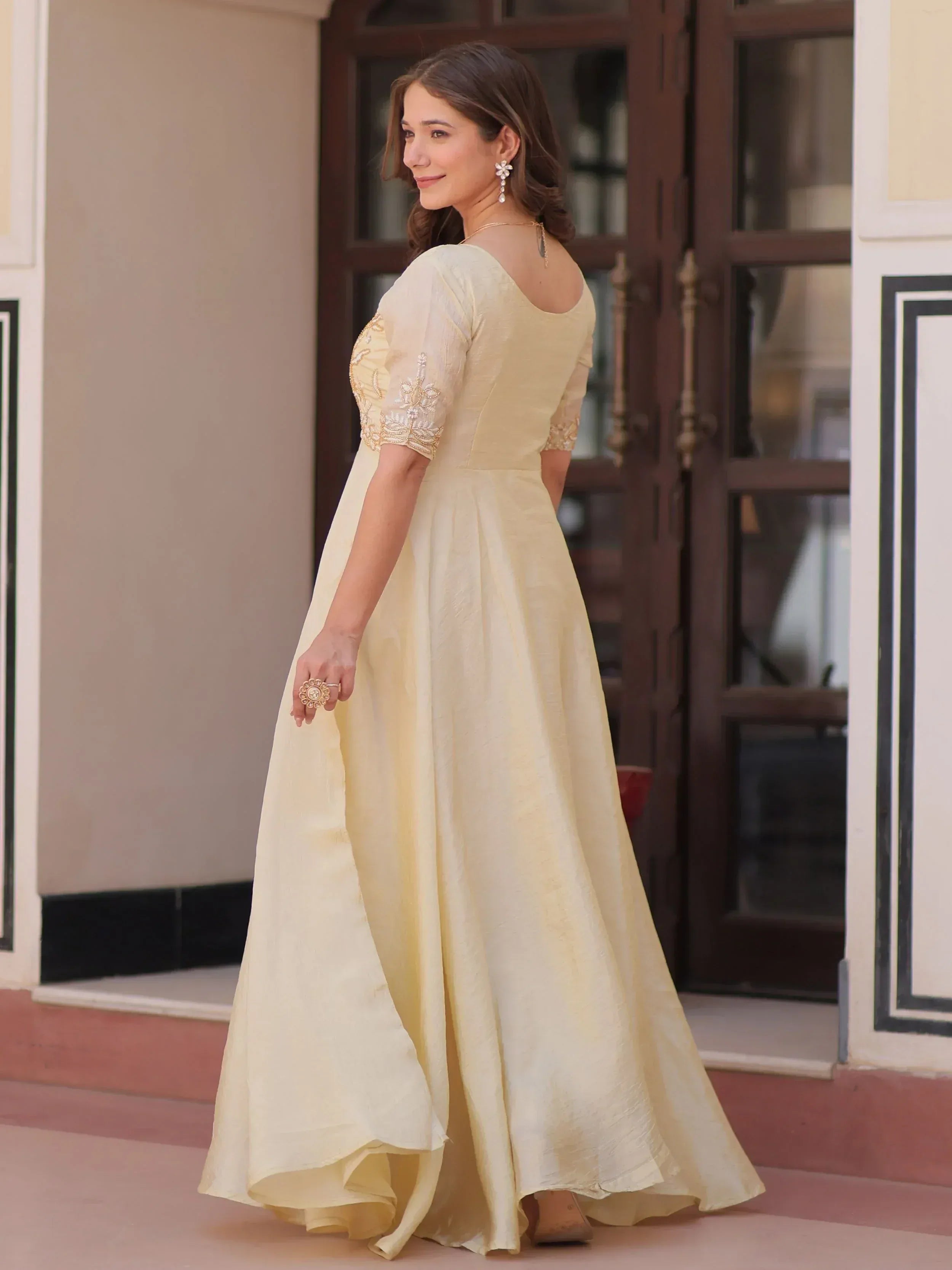 Elegant cream ethnic gown with embroidered sleeves, perfect for Indian weddings and parties