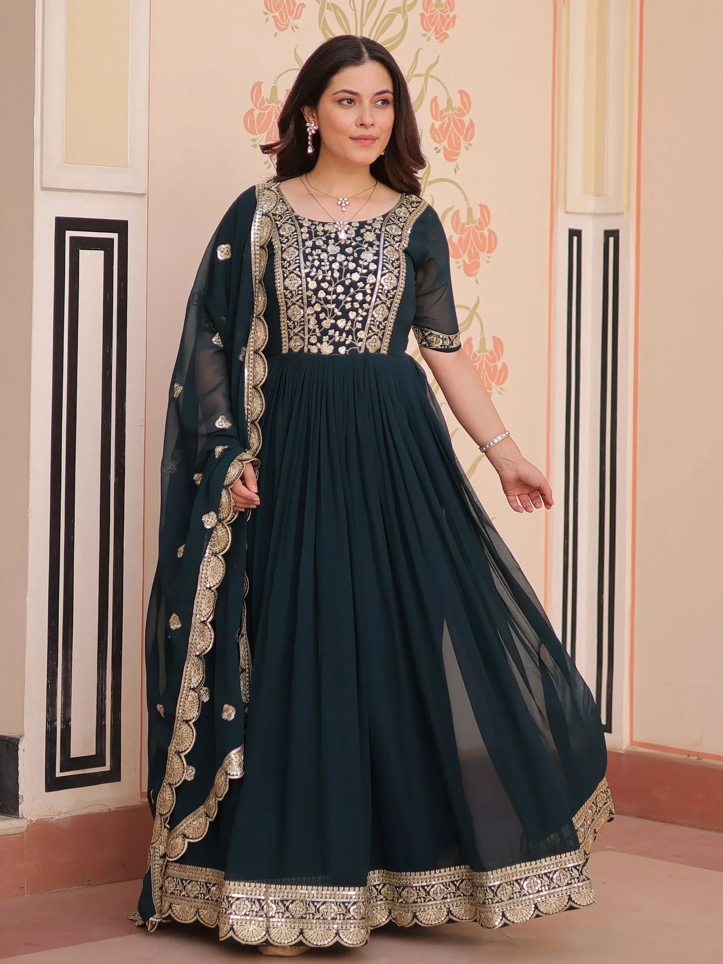 Dark green ethnic anarkali gown with gold embroidery and sheer dupatta, perfect for Indian festive occasions