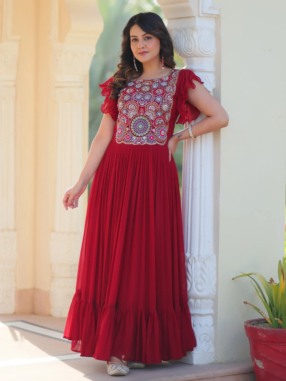 Red ethnic gown with embroidered floral bodice and ruffled sleeves, perfect for Indian occasions.