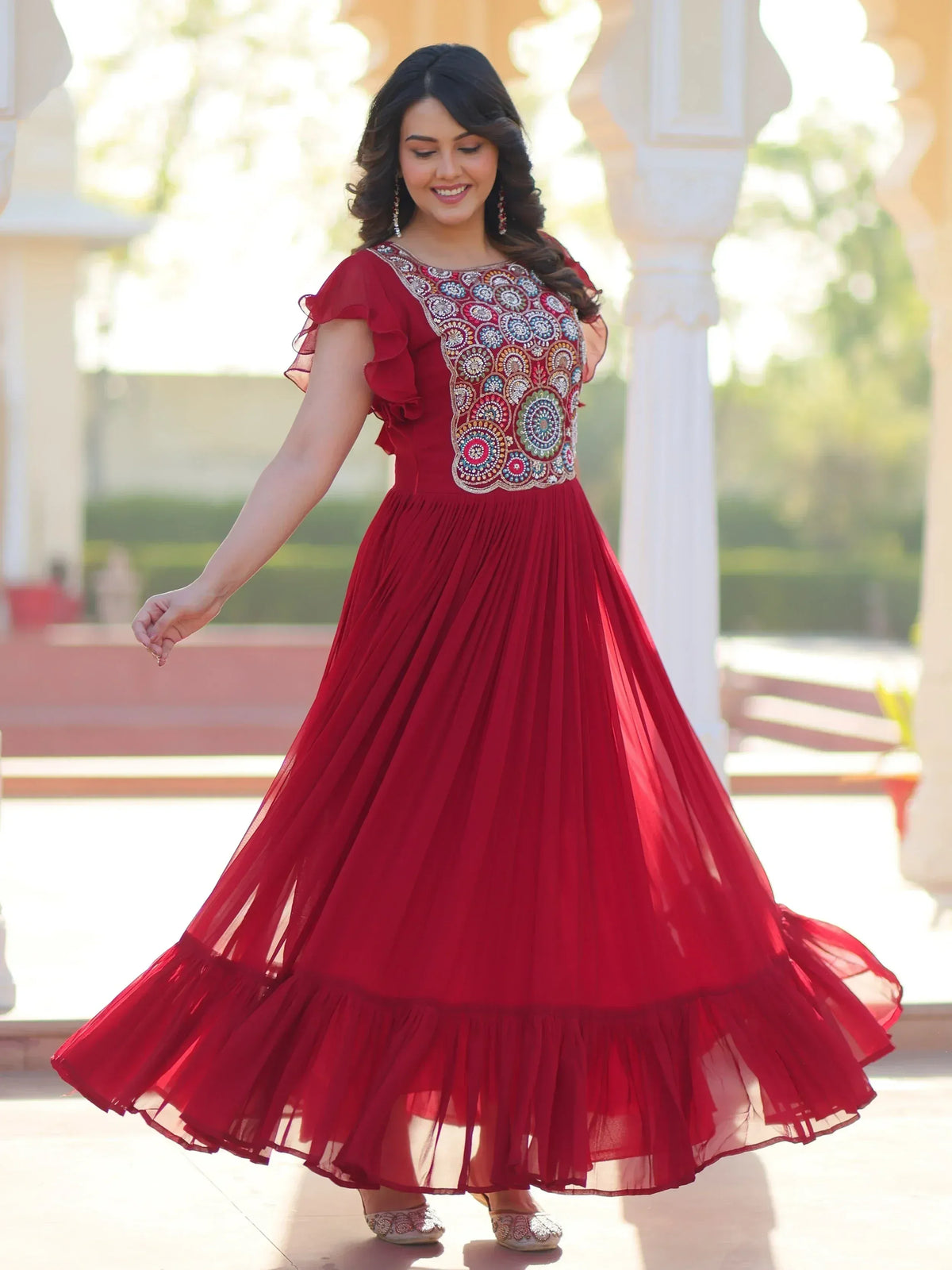 Red ethnic gown with intricate embroidery and ruffled sleeves for festive occasions