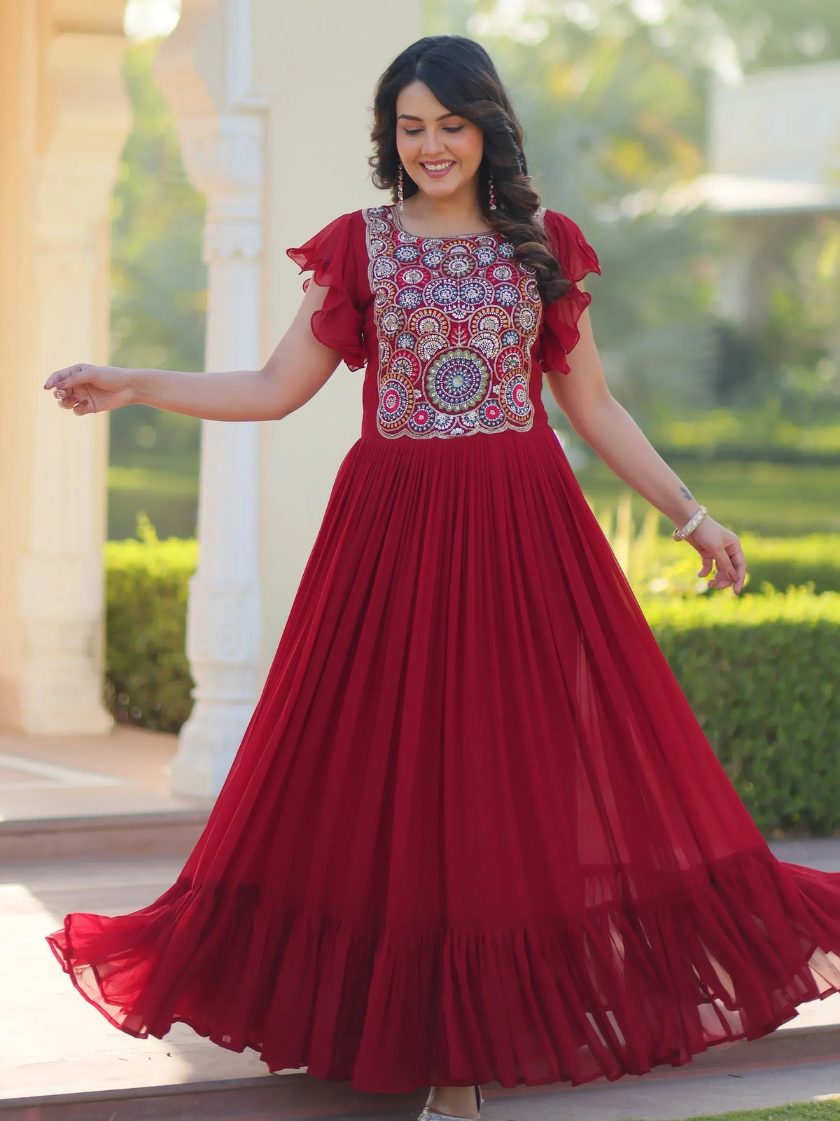 Red ethnic gown with intricate embroidery and ruffled sleeves, perfect for festive occasions.