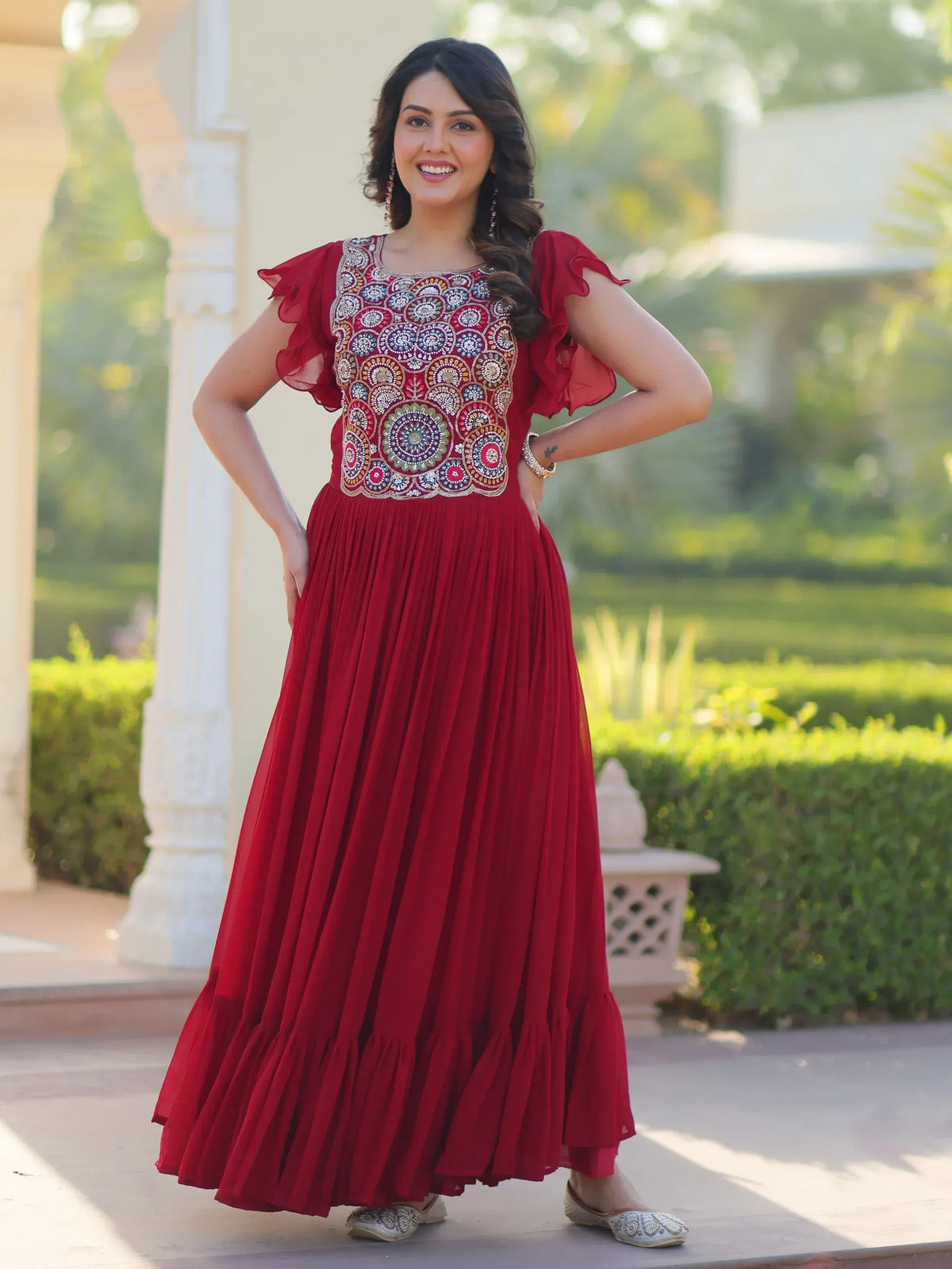 Red ethnic gown with floral embroidery, ruffled sleeves, and pleated skirt for Indian occasions